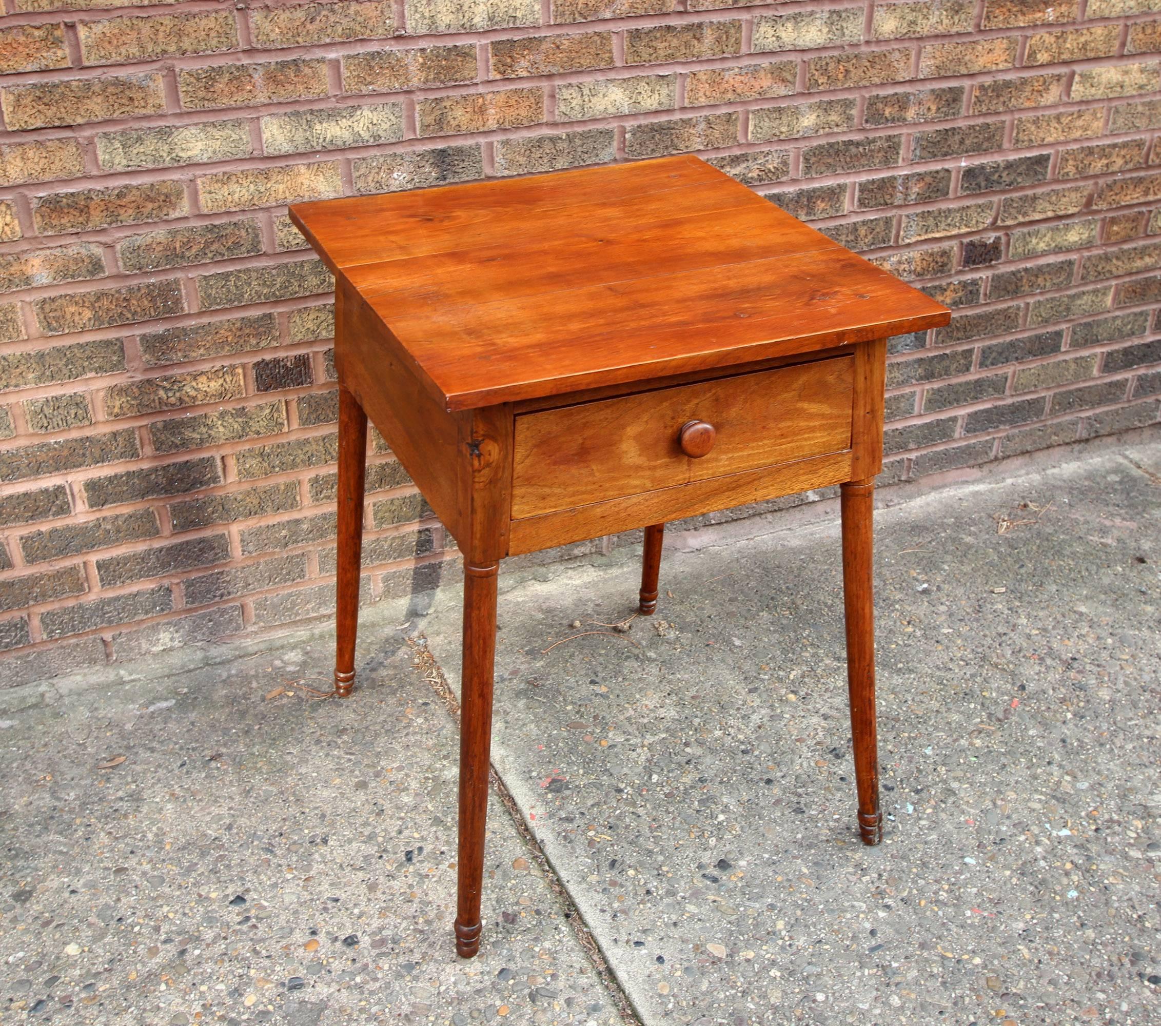 This is a handsome, substantial table with one dovetailed drawer with turned knob, turned legs with a whimsical splay, richly colored Cherrywood, American, circa 1840. Great patina and very sturdy.