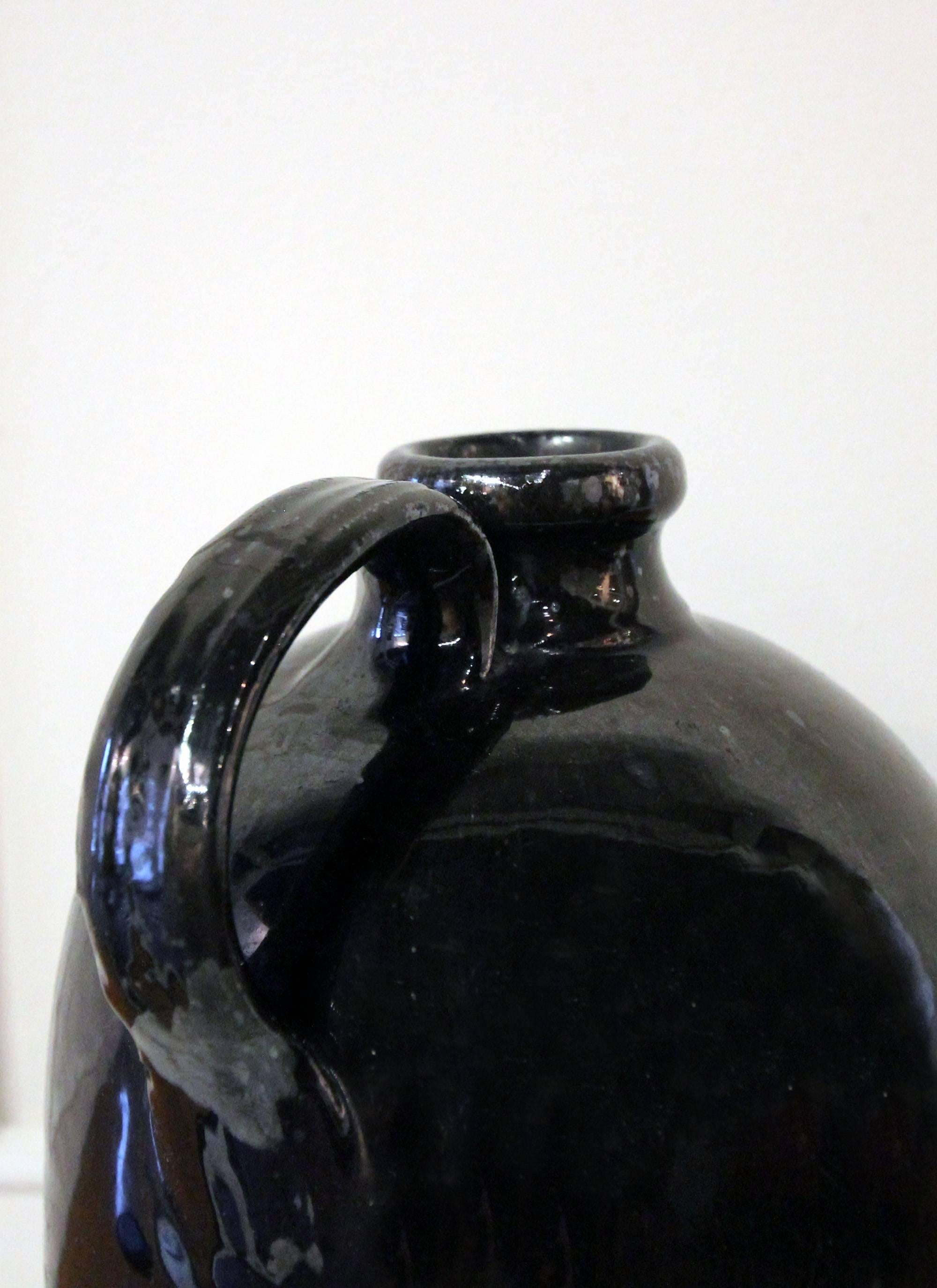 Mid-19th Century American redware jug with a manganese glaze, which is a handsome, slightly metallic black glaze; the underside is glazed as well. Hand-pulled, applied handle and trimmed line detail at the bottom.