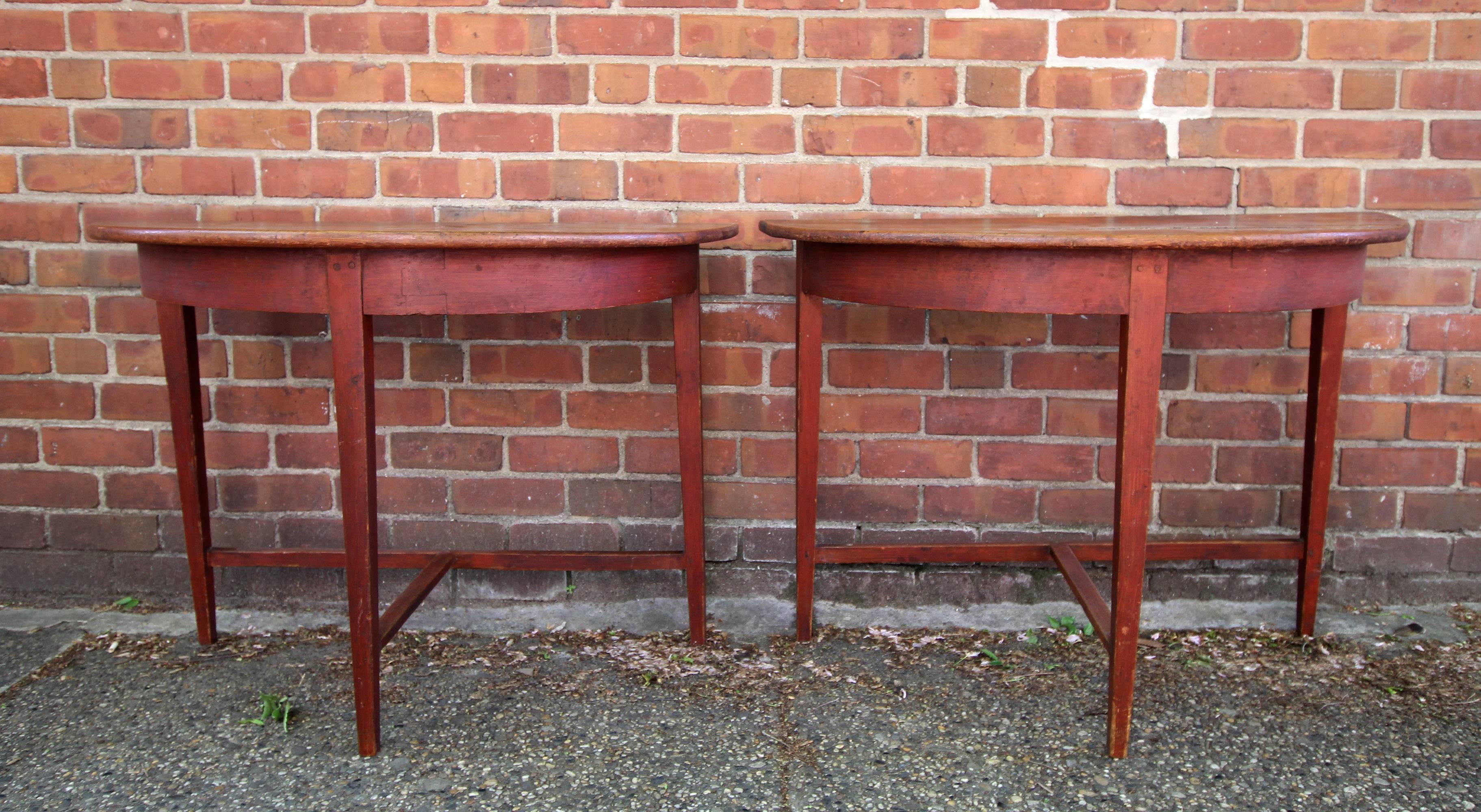 Pair of longleaf pine demilune tables with clean lines, tapered legs and t-shaped stretchers. Red washed bases and scrubbed tops. Mid-19th century American, probably southern. Notice that these two tables do not make one circular table when put