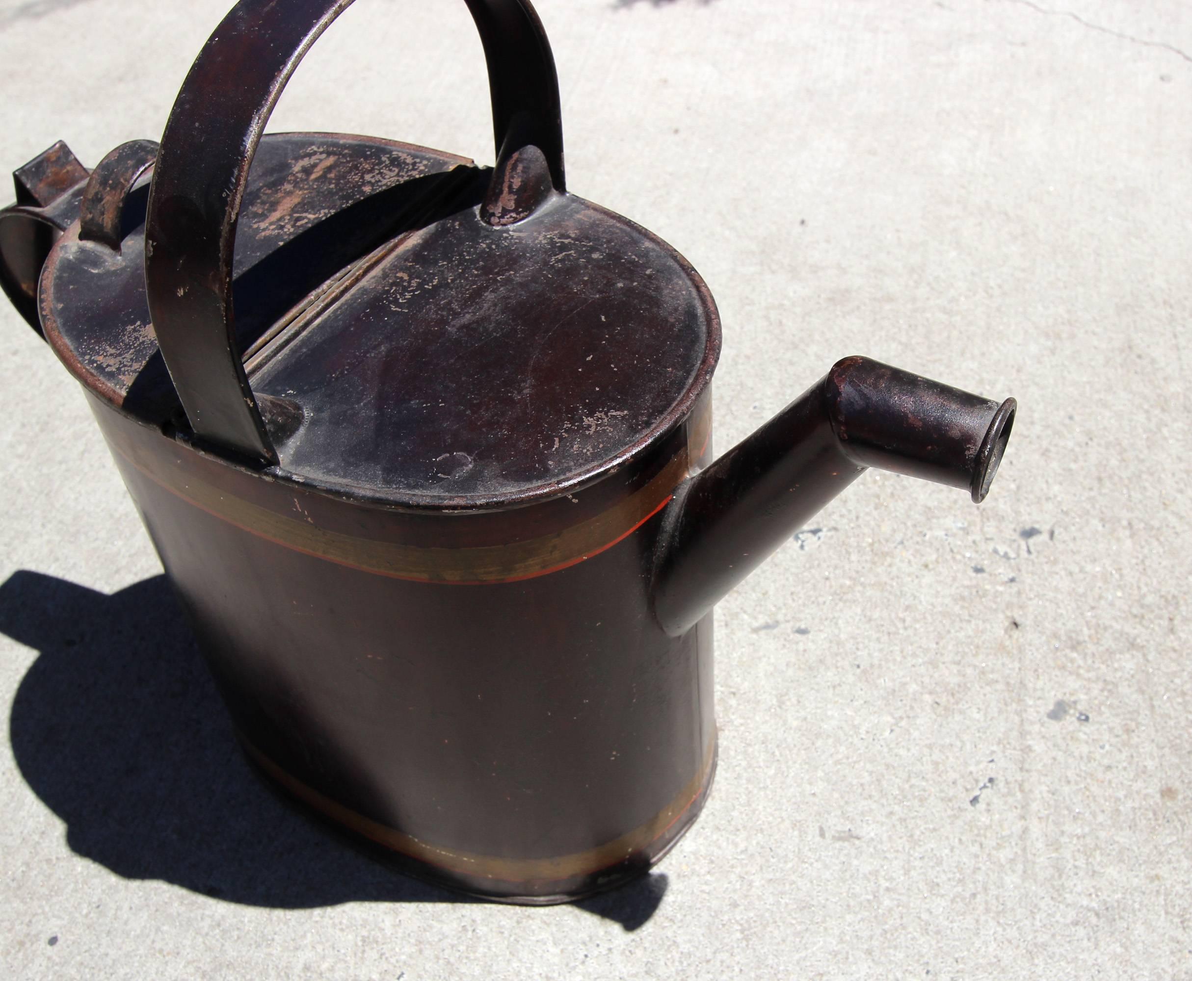 Good looking, large metallic black painted metal watering can with gold and red line decoration. Nice garden and Industrial appeal. Kreamer company stamp on the bottom. Early 20th century, American.