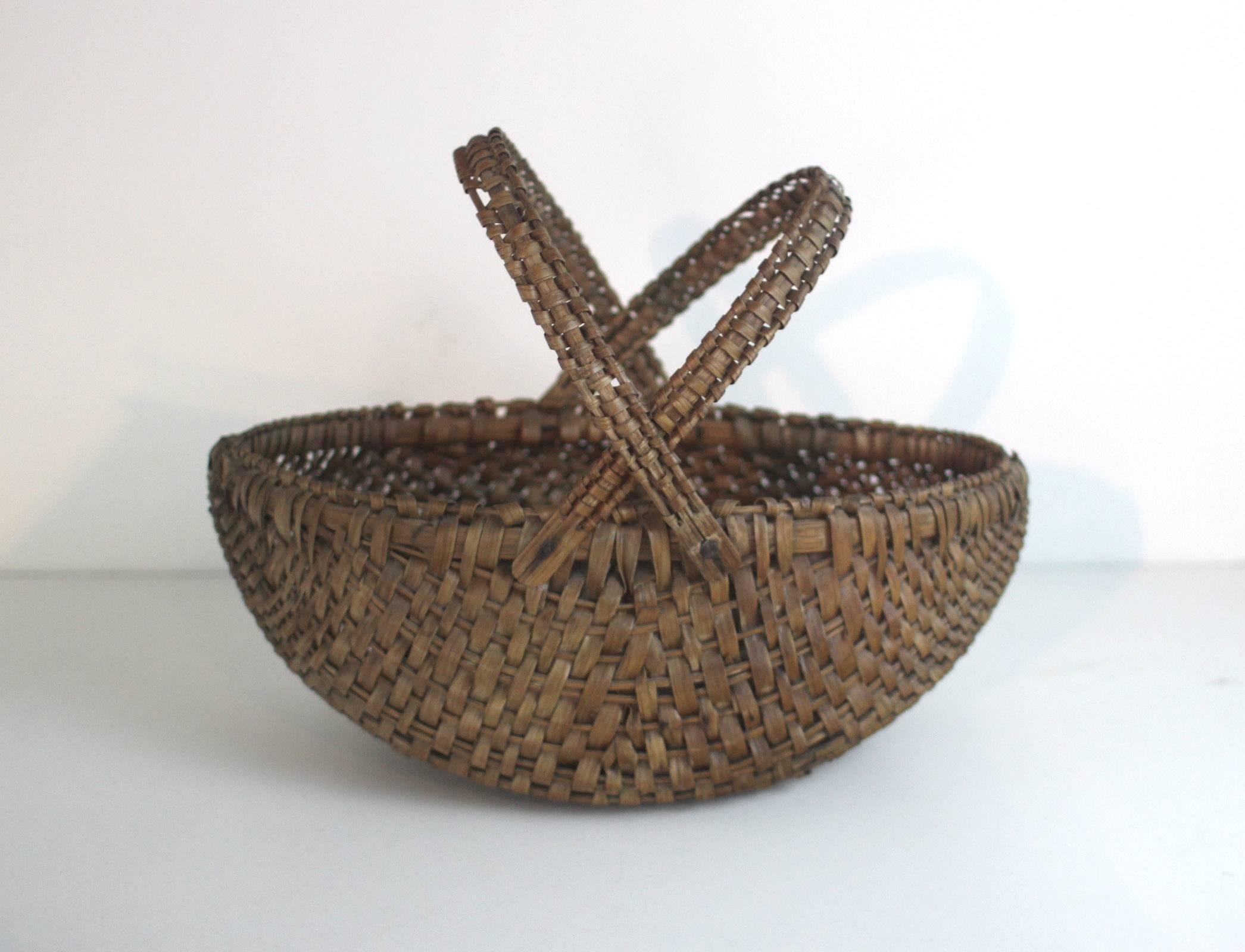 An excellent and rare form within 19th century American baskets with two swing handles and a very good ovoid shape. Warm deep nut-brown color.