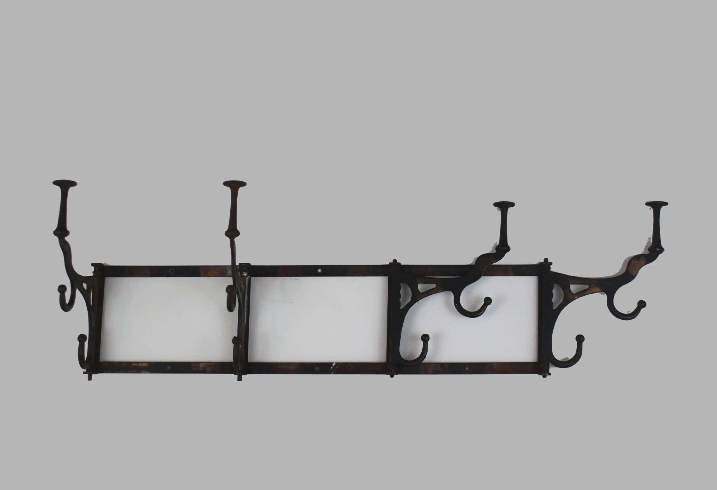 Very good and sturdy wall-mount cast iron rack with four locking swing-arm triple hooks. Would work well for narrow halls or small rooms as the hooks can lay flat when not in use. Iron, circa 1900. Good for coats, hats etc.