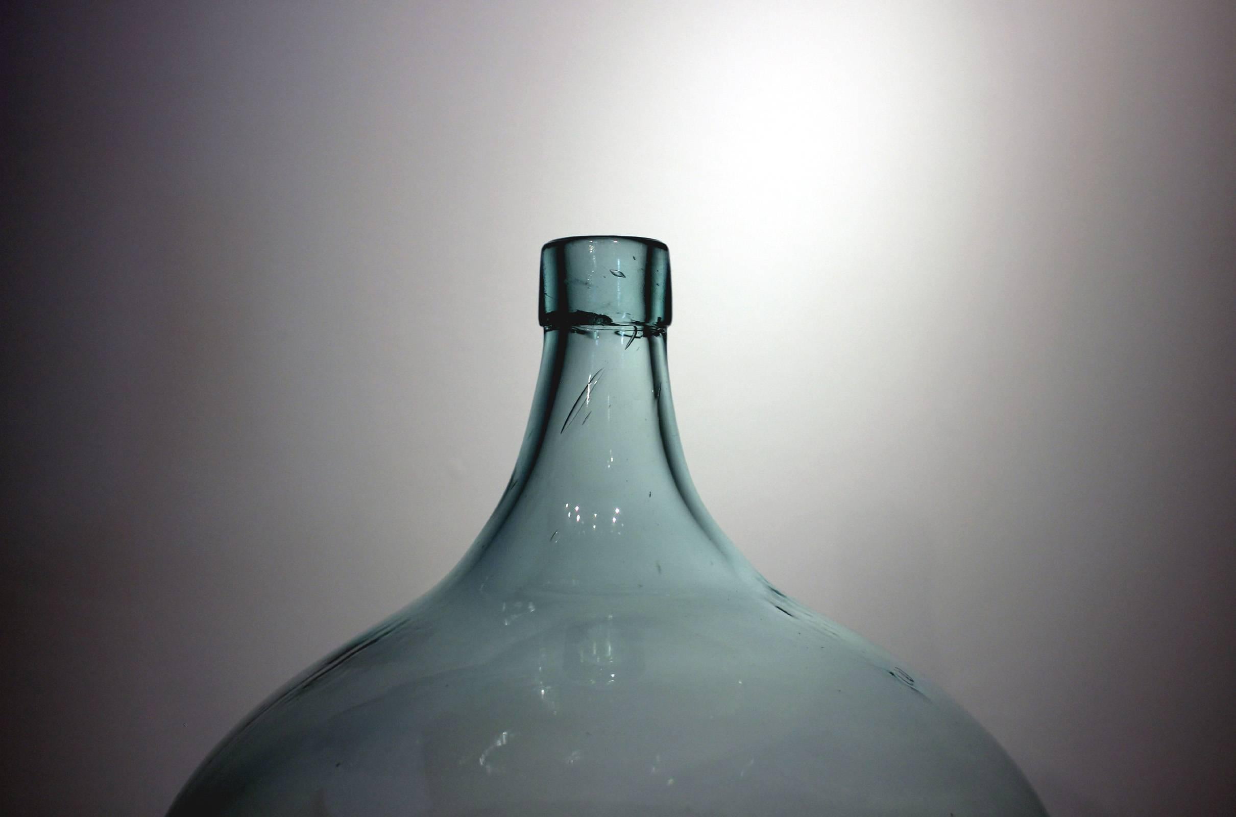 Large and beautifully formed aquamarine blown glass demijohn bottle, American, late 19th century. Excellent condition.