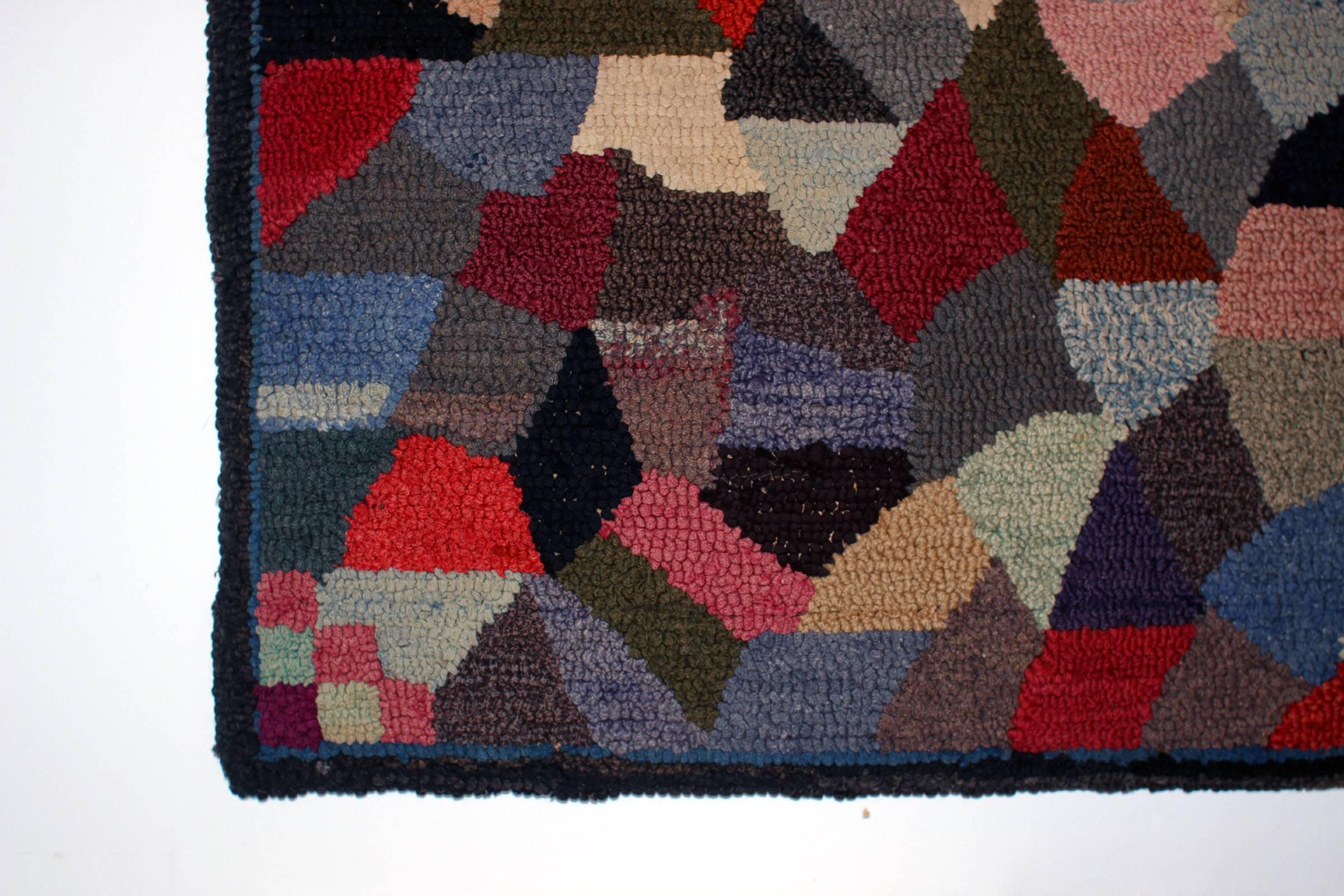 Hooked rug in strong color and appealing abstract design. With narrow border and notable block-patterned corner details; American, early 20th century. Handmade and in excellent condition. Could be used on the floor or hanging on a wall.