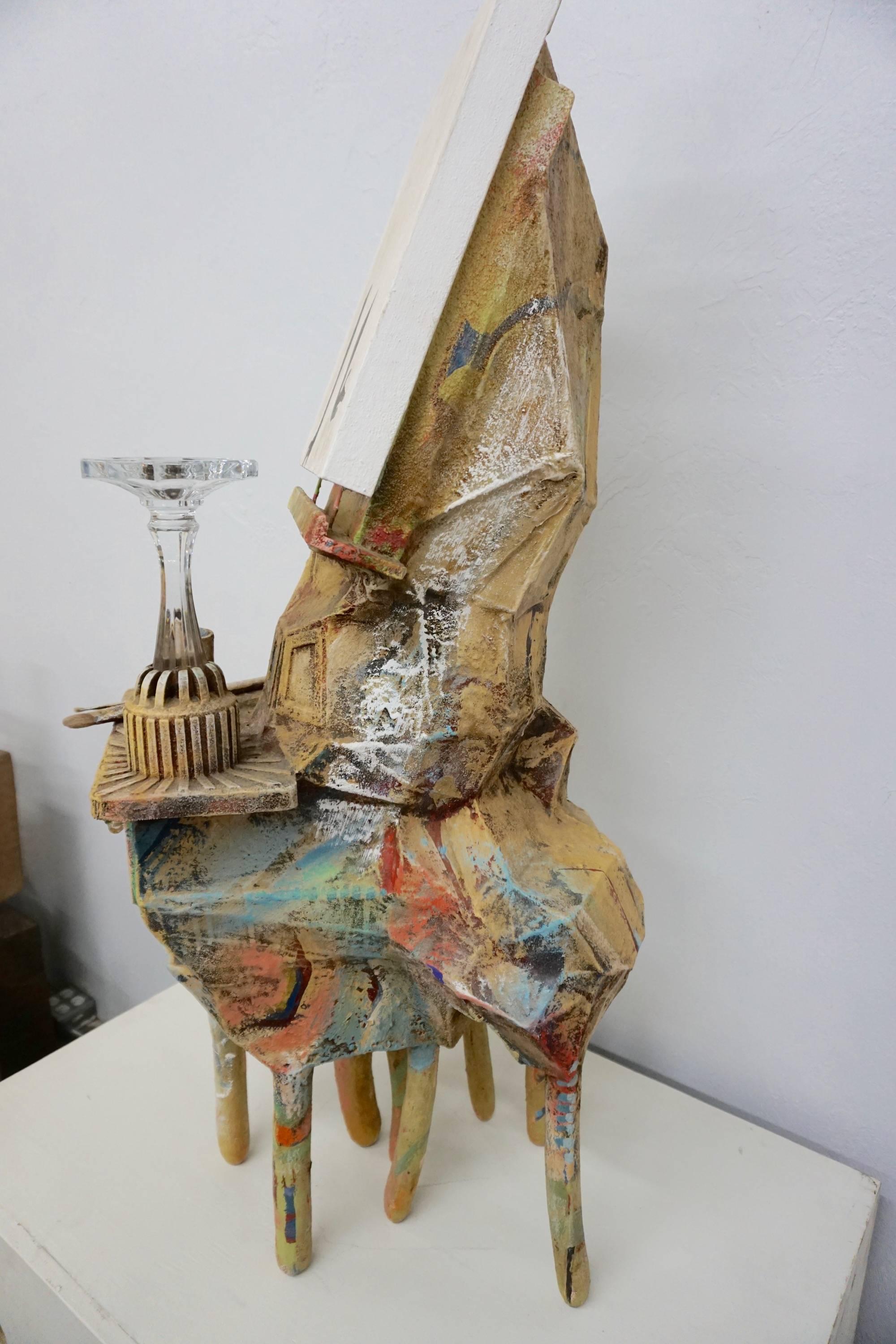 Found objects transformed into a unique work of art resembling an easel. Resin coated and spray painted, with artists tools, bones and a painted canvas as part of the assemblage.