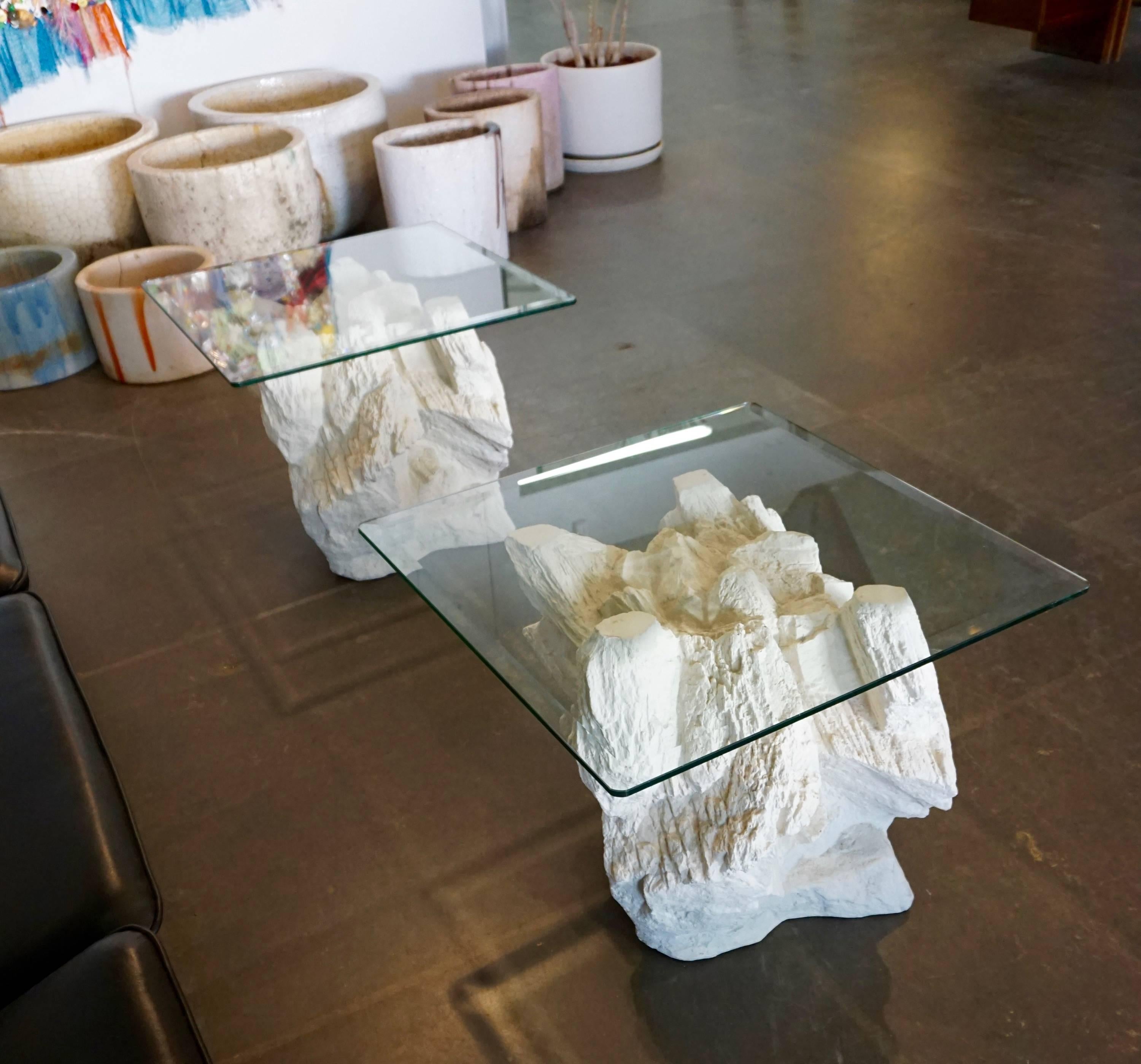 Hollow cast plaster giving the impression of a pile of rocks. Off-white in color with beveled glass tops. Also available are a console and a coffee table.
The bases measure 19.5