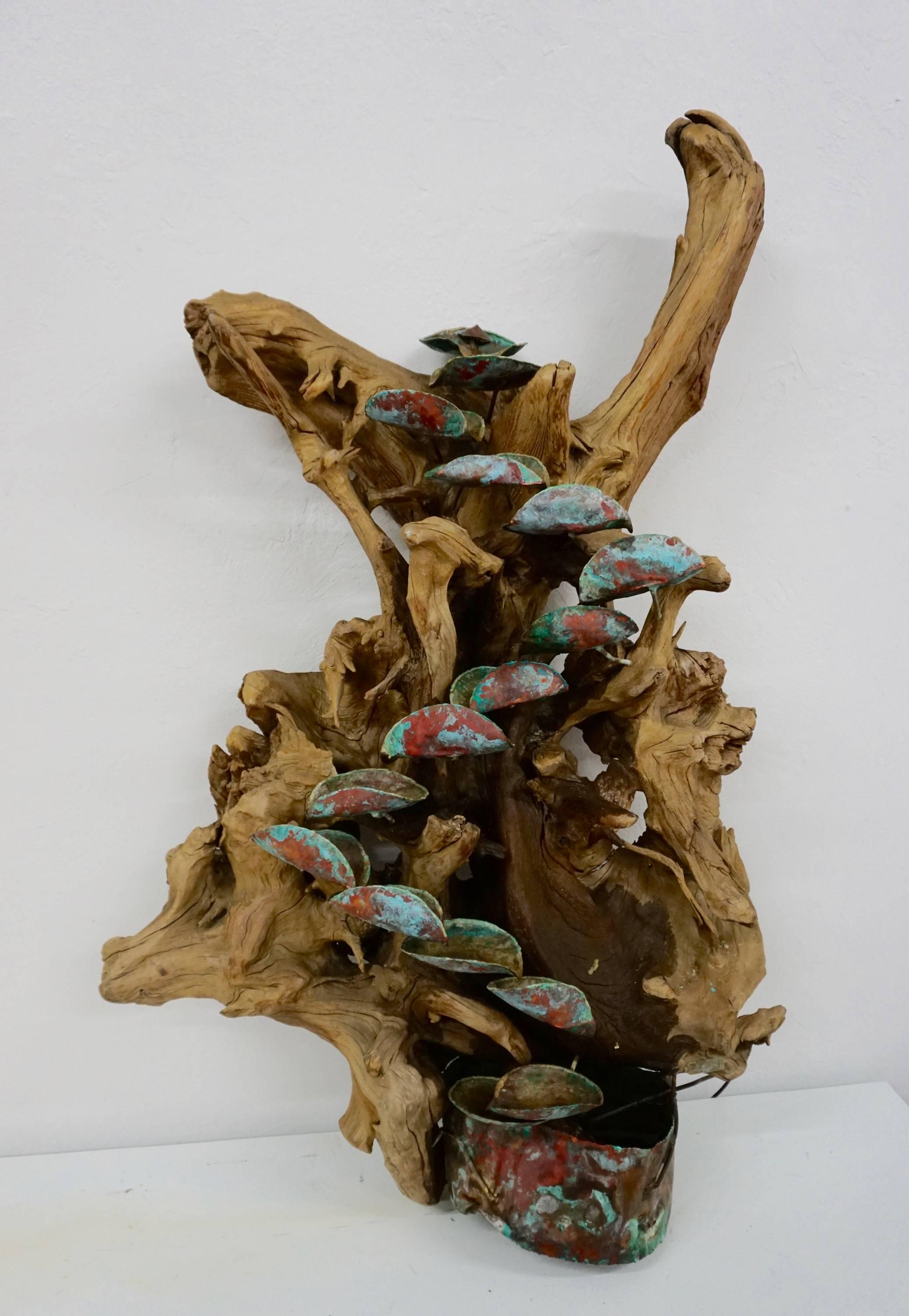 Beautiful organic driftwood fountain with descending copper cups flowing in to a copper basin housing the water pump. Can be wall-mounted or rested against a wall.