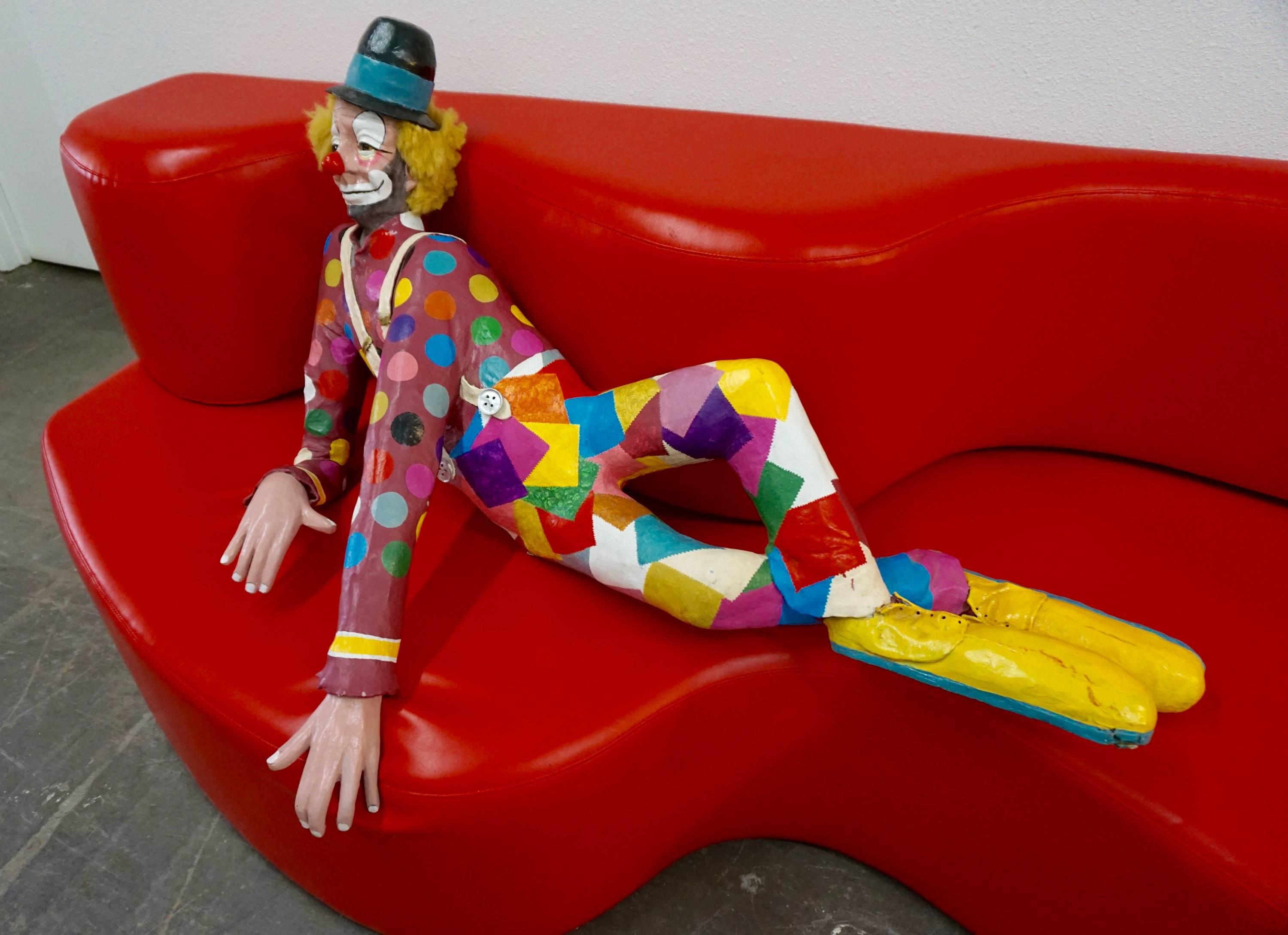Papier mâché likeness of a reclining circus clown, hand-painted. Signed and dated "James Kidd 1991".