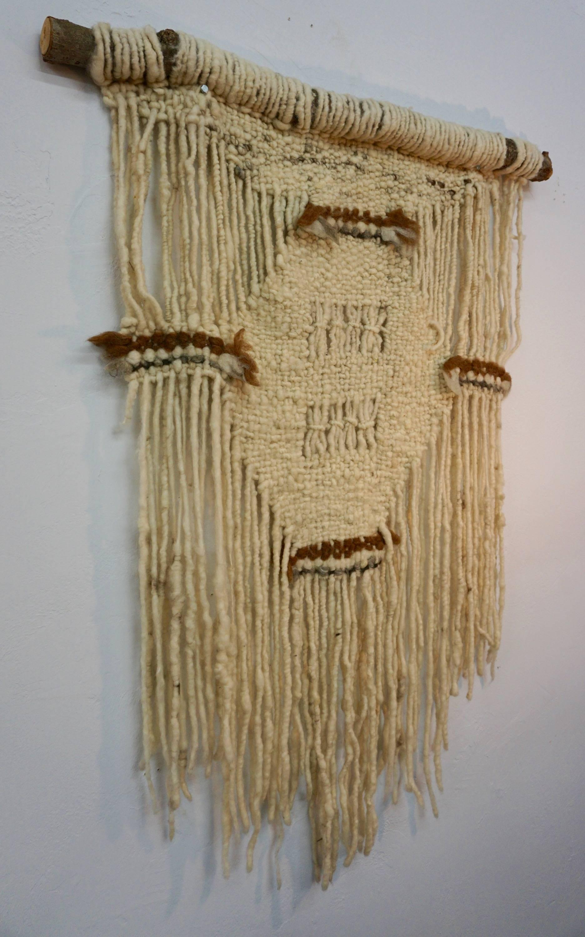 Organic hand spun wool hung from a tree limb. Subtle earth tones express the simple beauty of this piece.