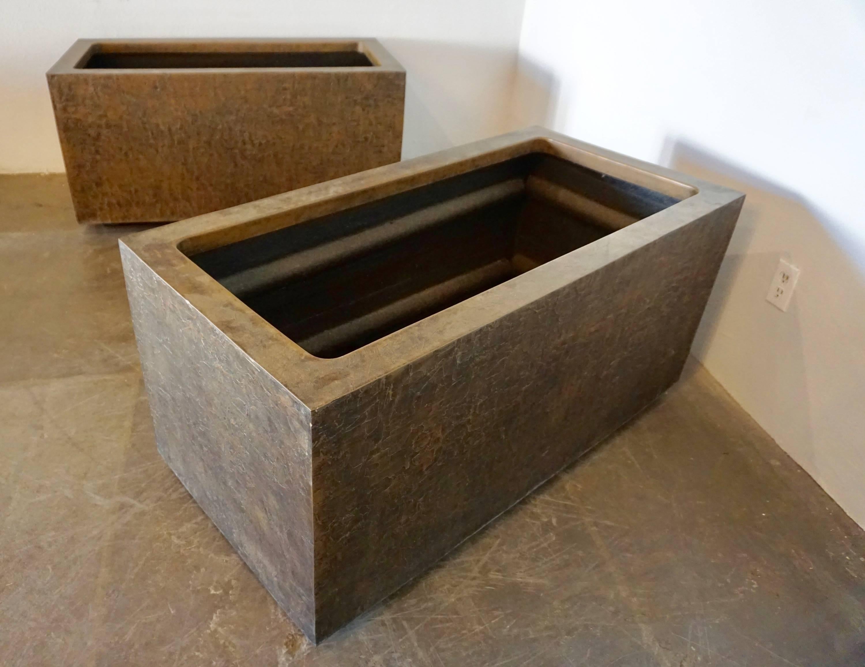 Pair of large, 1970s rectangular planters made by forms and surfaces, Santa Barbara, Ca. They are made of sturdy fiberglass inside with a beautiful Brutalist pattern of bonded bronze on the exterior. For indoor or outdoor use.