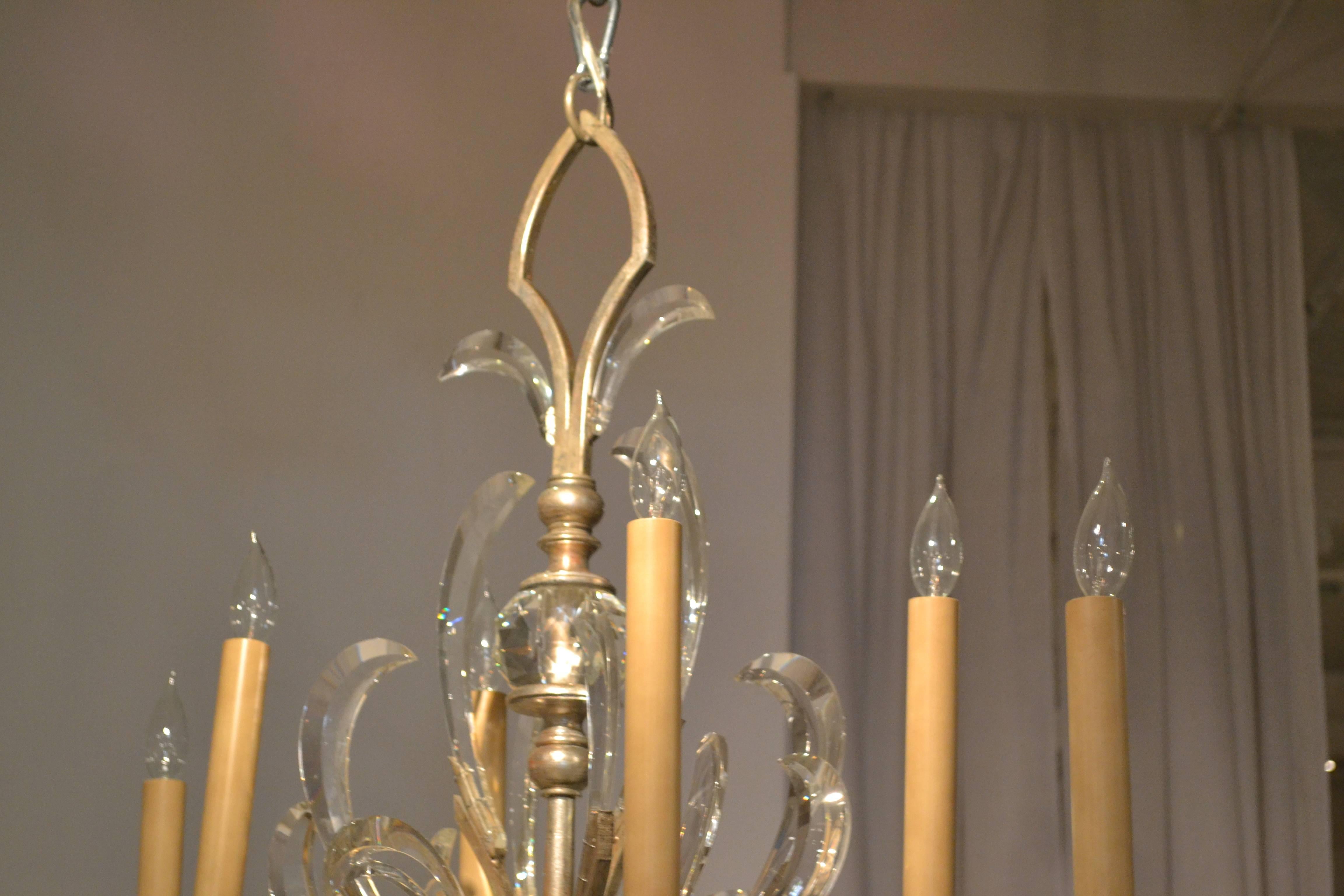 A vintage oblong six-light Italian chandelier, circa 1970s, finished in muted silver leaf with beveled crystal accents is absolutely elegant. It is 50 inches wide and 37 inches high and has six 13 inch tall faux candles with clear glass flame and a