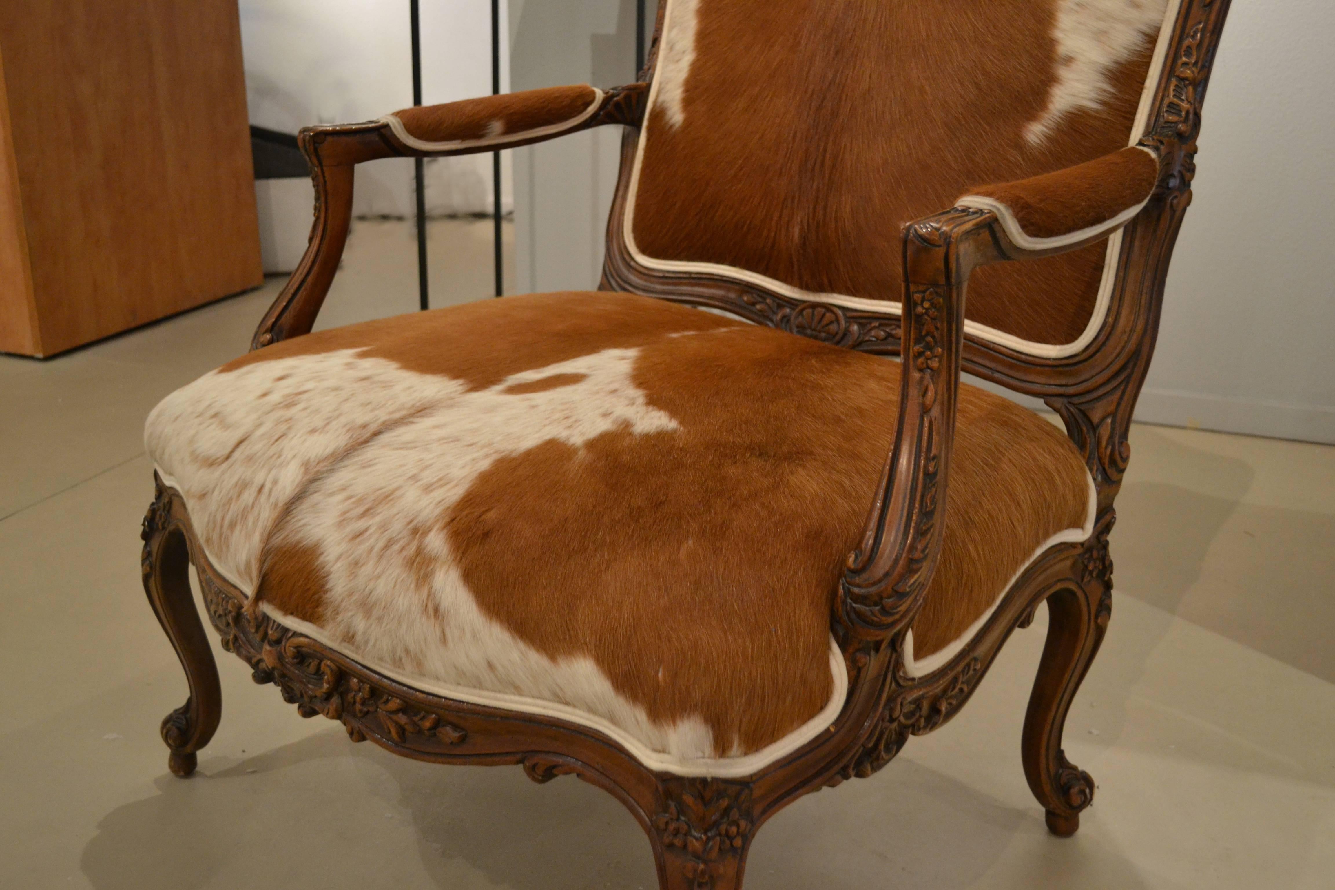 This elegant and beautifully carved, Mid-Century Louis XV Fauteuil a la Rein from France is lavishly upholstered in horse hair. Carvings of flowers on centre and side of crest rail, bottom rail and knees, with carvings on feet. Four cabriole legs
