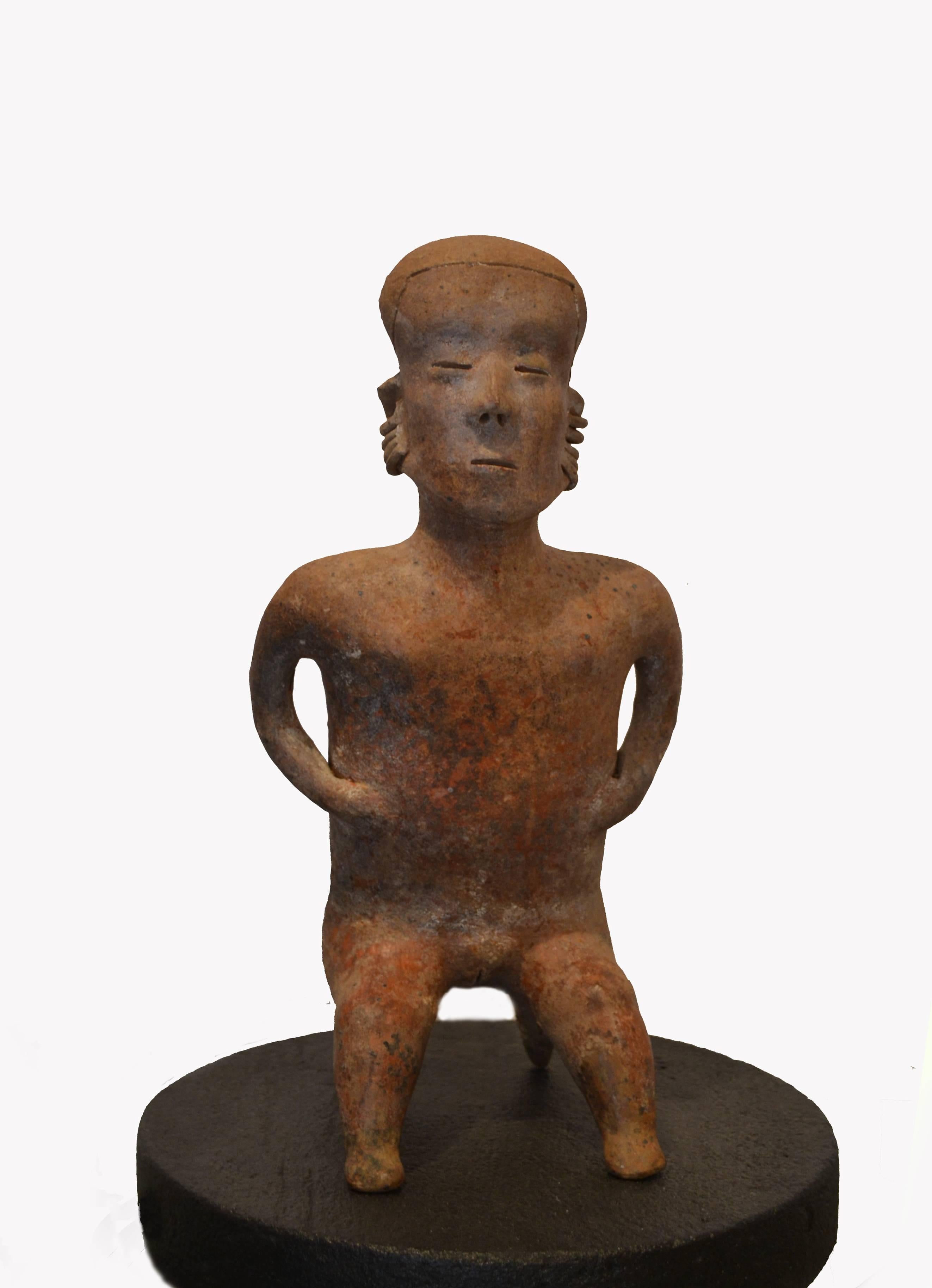 An exceptional and monumental seated figure of a female in birth position, with red, black and white pigment. Protoclassic, circa 100 B.C.-250 A.D., from Nayarit, Mexico. Black pedestal (shown) not included.