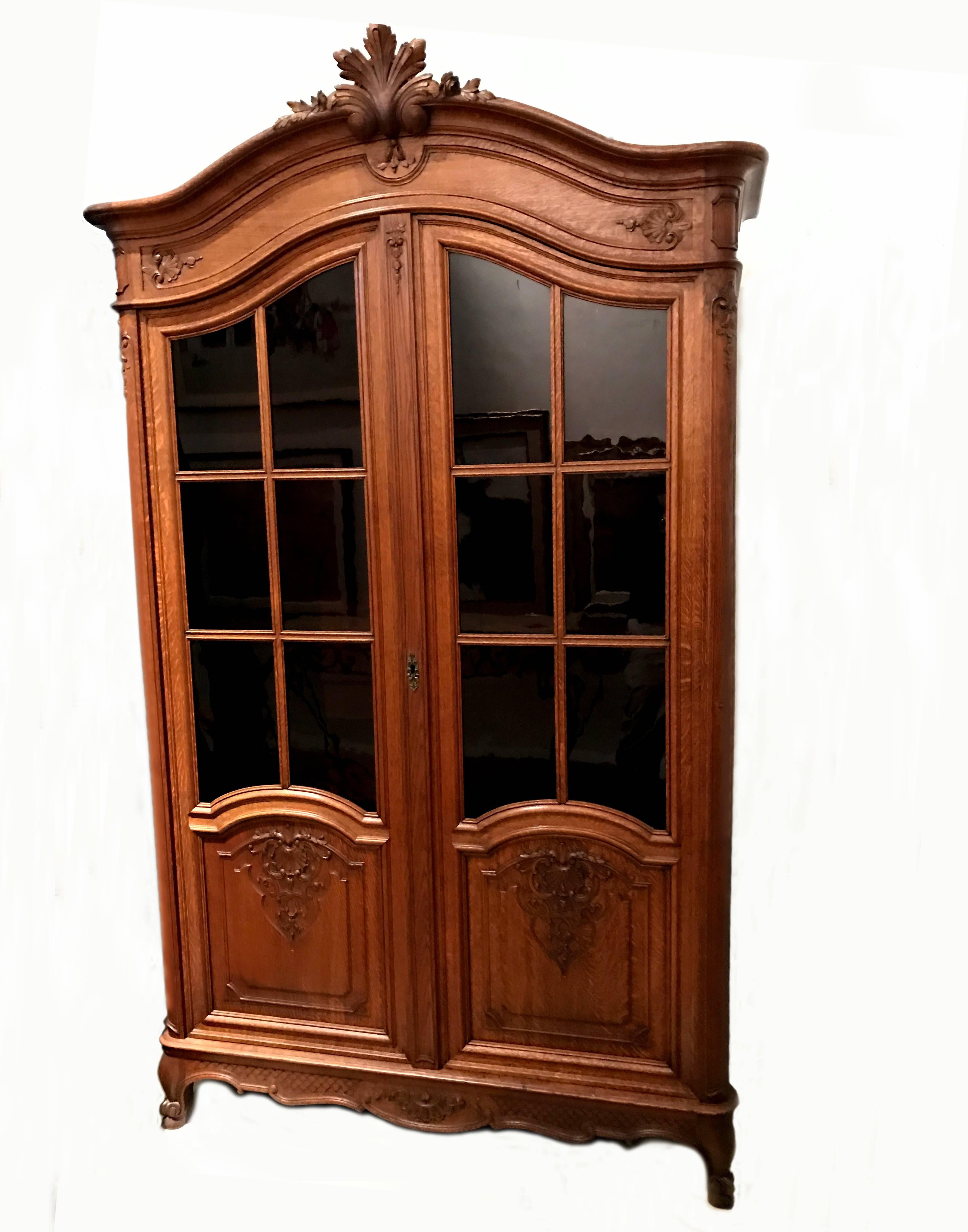 A superb pair of vintage French Regency armoires with pane glass doors and carved Acanthus leaf crown mount. Both armoires are in near perfect condition and are exactly the same dimension and design. 

The original interiors were recently
