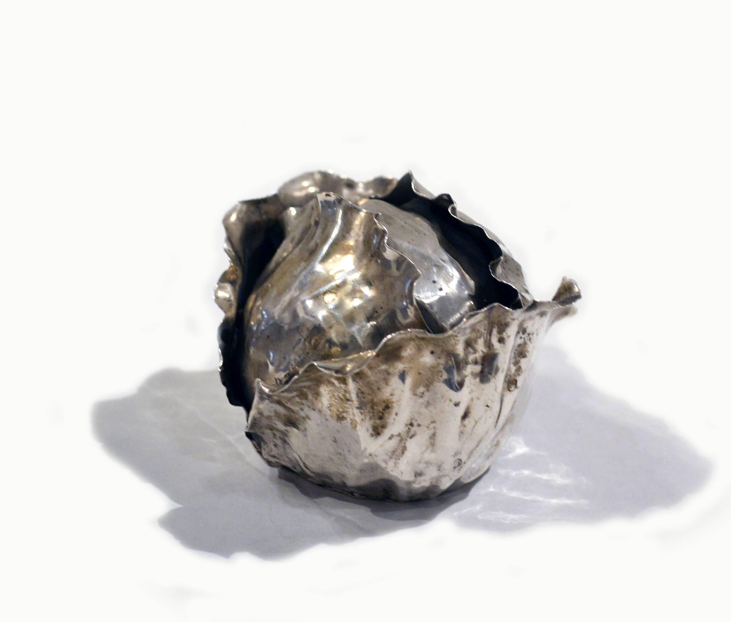 Handcrafted in Italy in the late 1960s, this sterling silver lighter in the form of cabbage was created by famed silversmith and jewelry designer Buccellati. This piece is marked atop the rim of the lighter's chamber. The sterling leaves mimic real