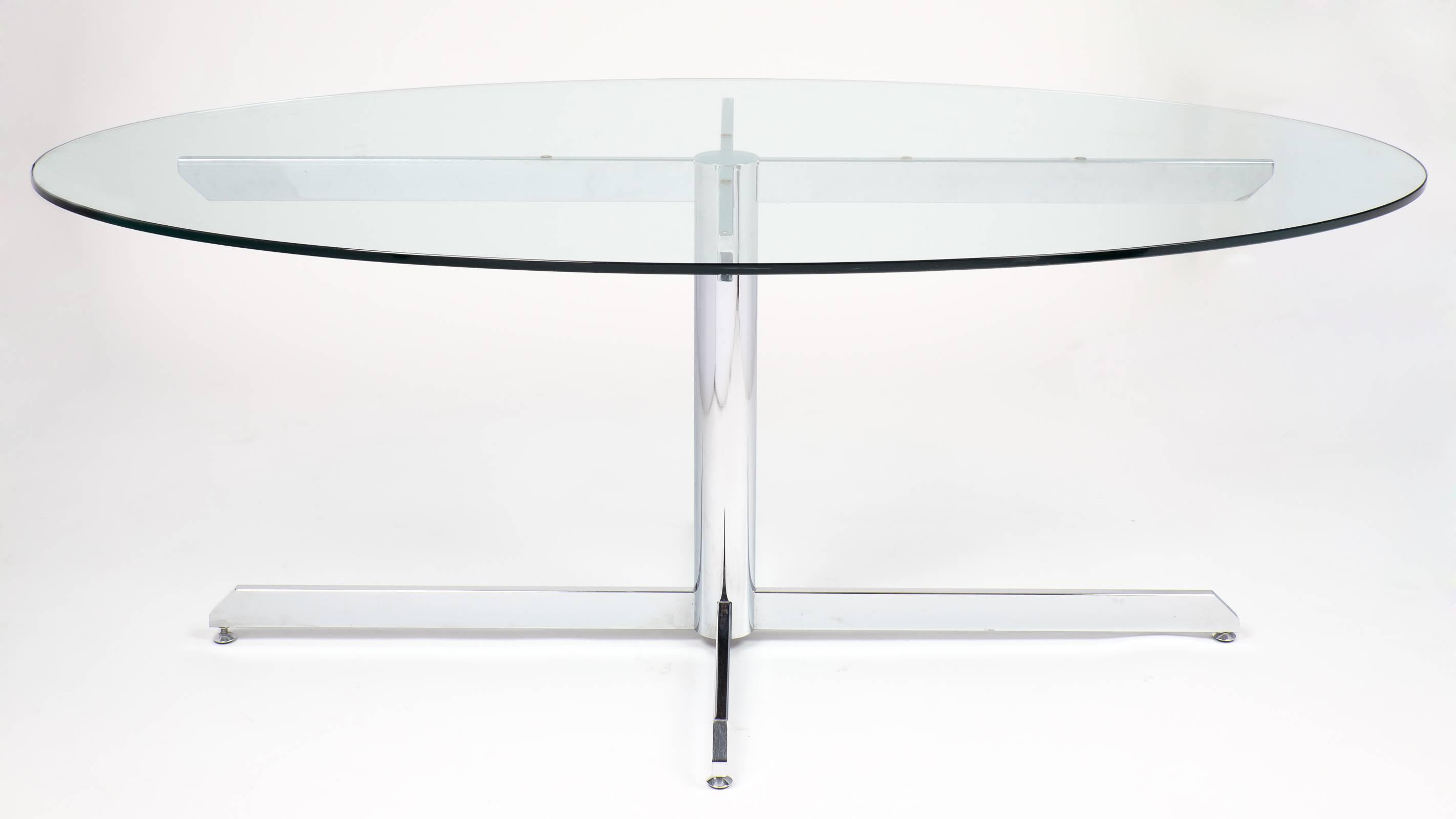 A sleek, crisp French modernist oval glass and chrome Knoll style dining table that is balanced perfectly by opposing geometric shapes. Equally great in an office setting or in the dining room. Options for seating is literally wide open making it a