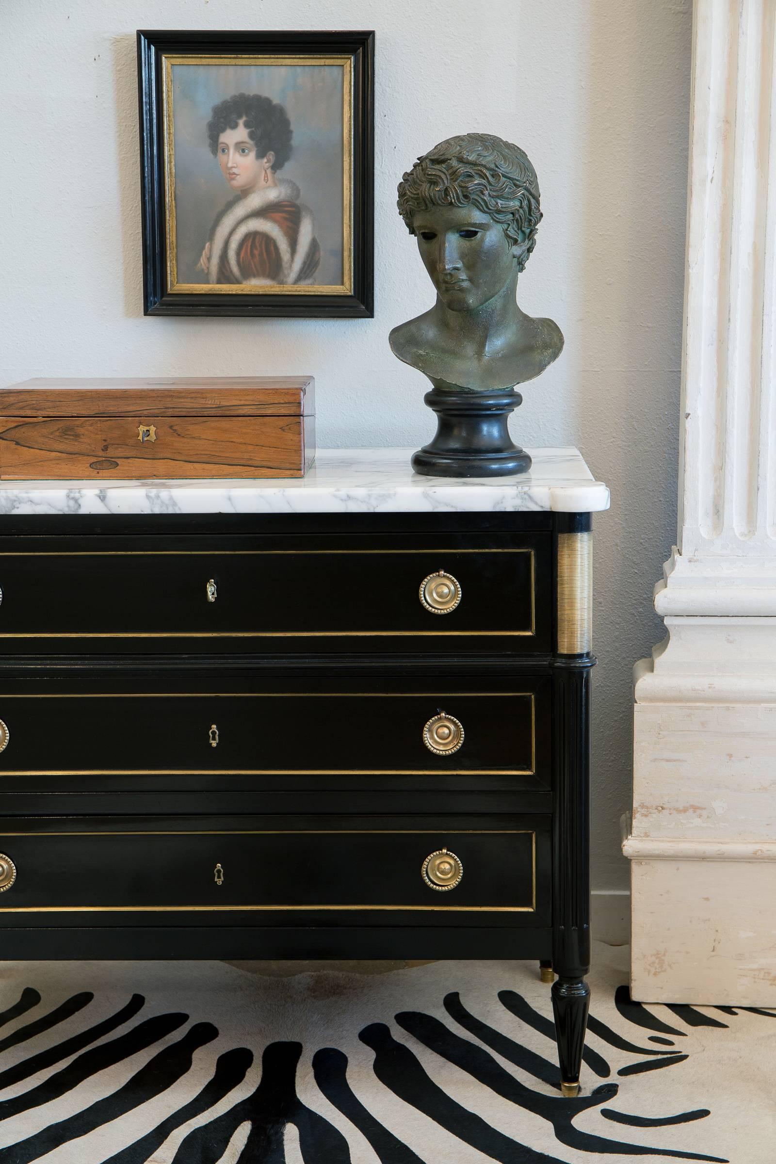 A high quality solid mahogany chest of drawers in the Louis XVI style with a thick Carrara marble slab. Gilt trim throughout and finely cast decorative hardware. The perfect sleek neoclassic chest for you r entry way or bedside table.