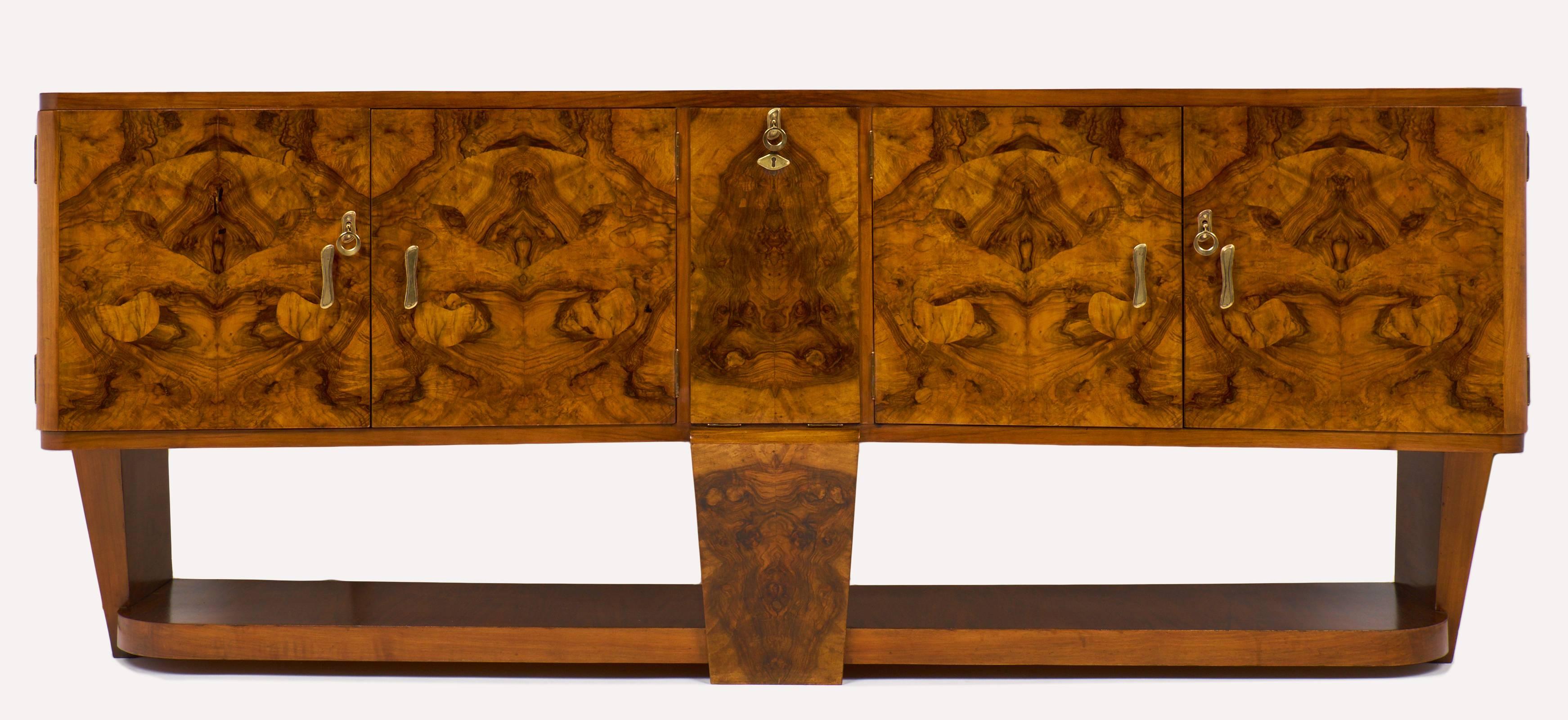 From Italy gorgeous burled walnut credenza/bar in the manner of Carlo di Carli.
We love the drop front bar compartment lined with mirror and of course the intricate figuring of the burled walnut. Solid brass hardware, French polish finish.