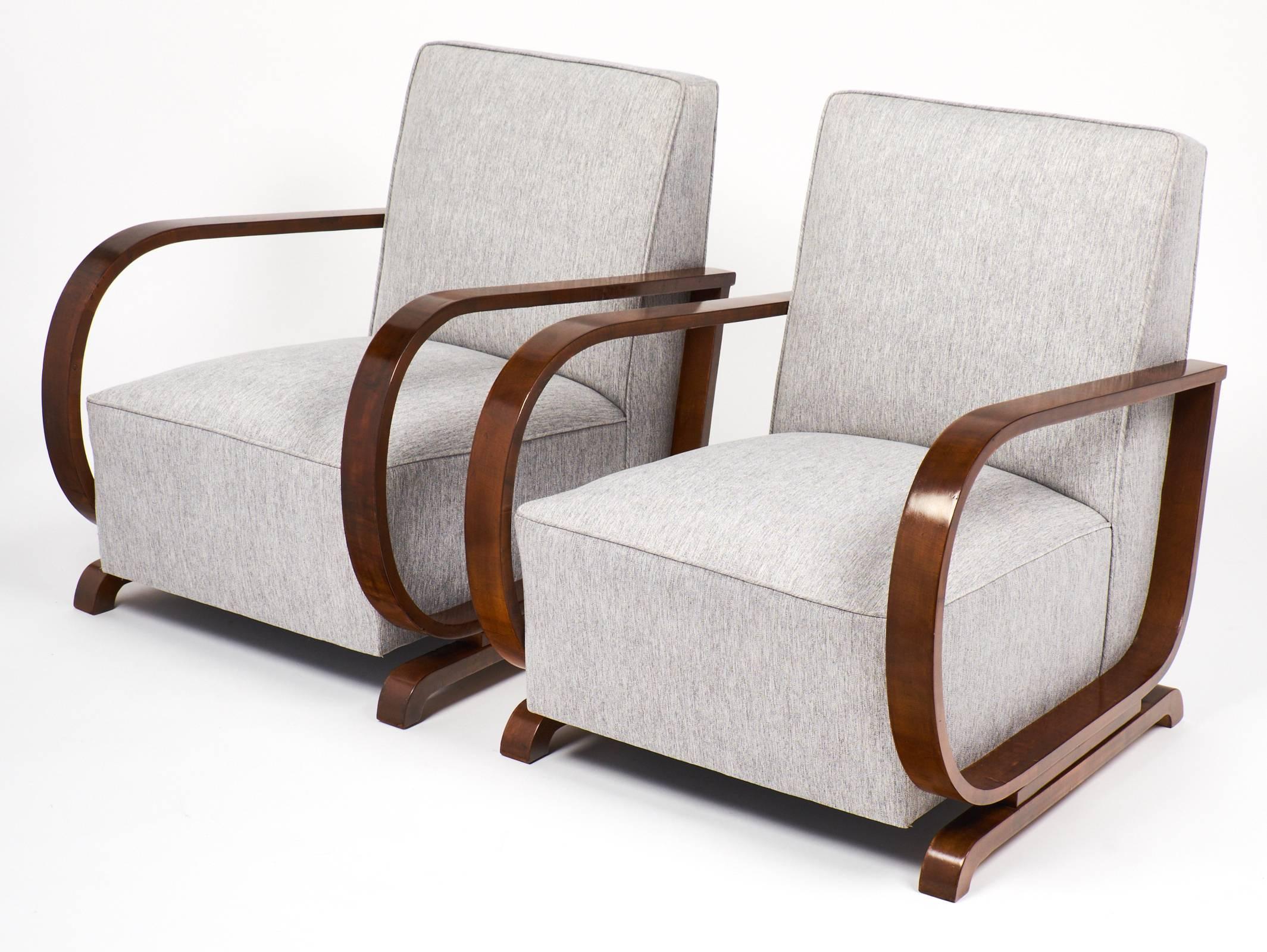 Pair of Art Deco armchairs from Vienna (Austria.) Strong solid walnut frames finished with a lustrous French polish. Dynamic lines and comfortable lounge seating. Professionally upholstered in a linen blend.