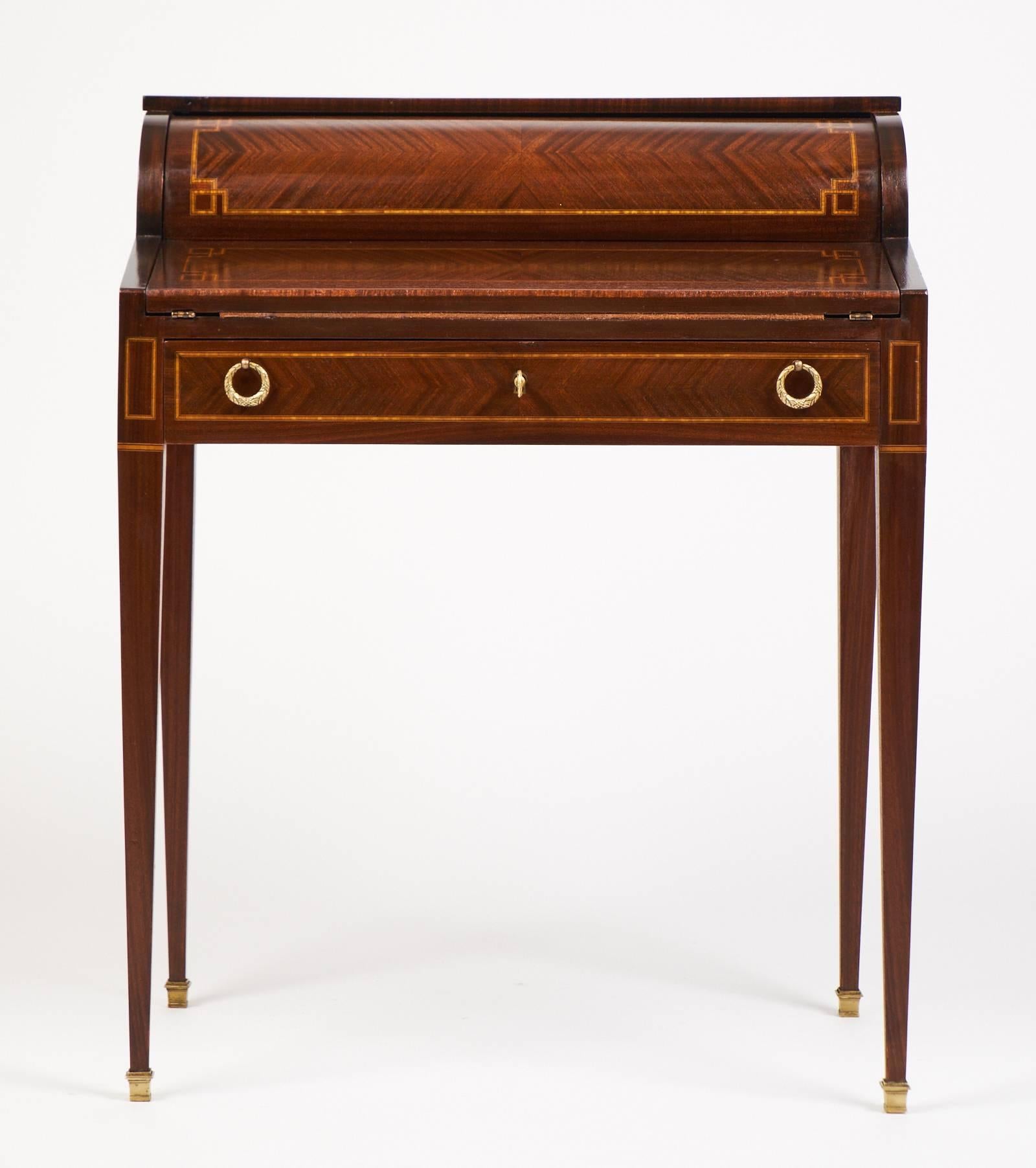 Antique Louis XVI cylinder bureau, secretary desk. A retractable cylinder encloses three drawers and a leather topped writing surface with a large bottom drawer below. Tapered legs with polished brass capped feet, original hardware, lock and key. A