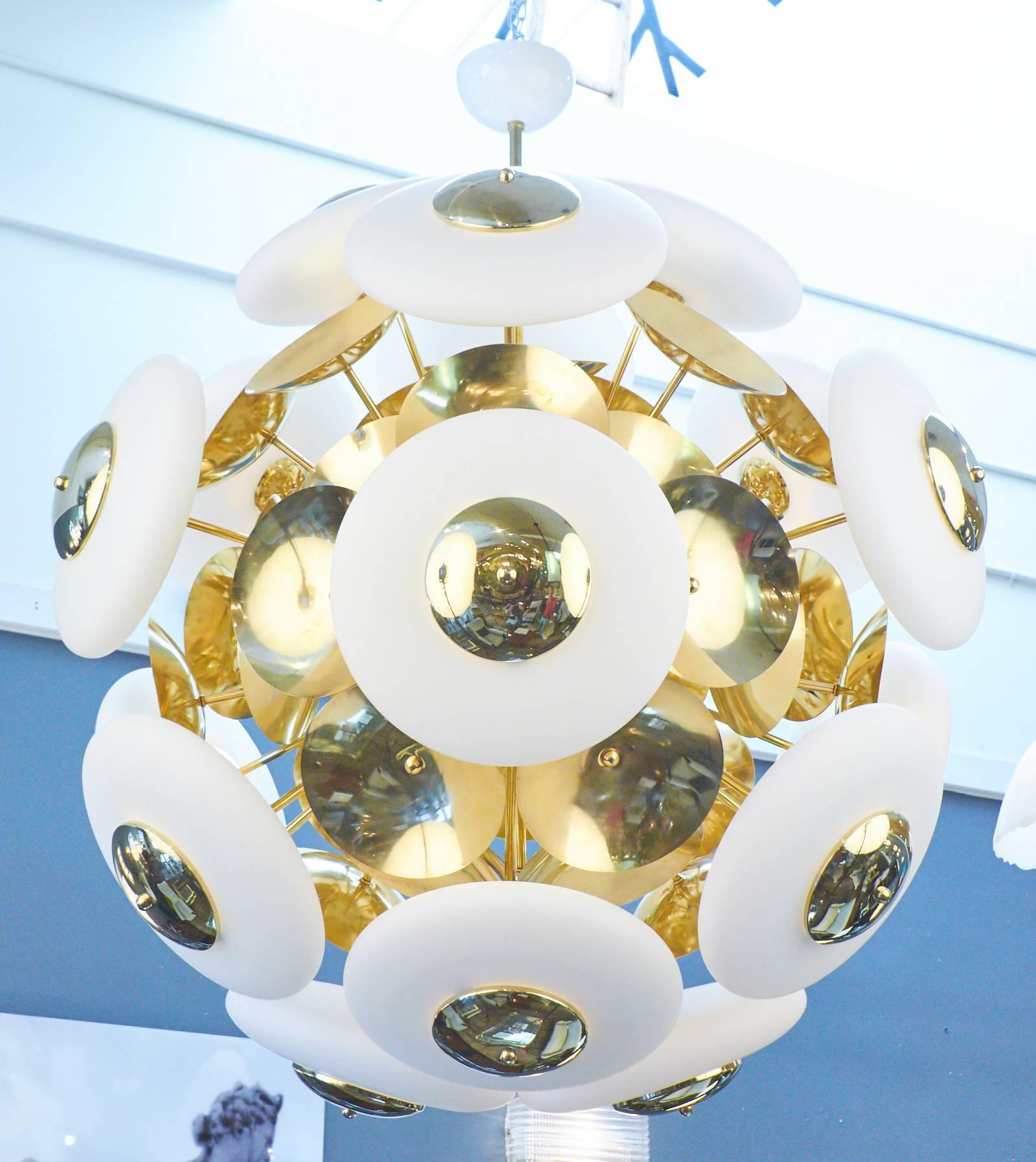 A unique and wonderful Italian chandelier with 18 white Murano glass orb shades complimented by brass discs on a spherical structure. Rewired for the US.

This fixture is currently located at our dealer's warehouse in Italy. Please contact us for a