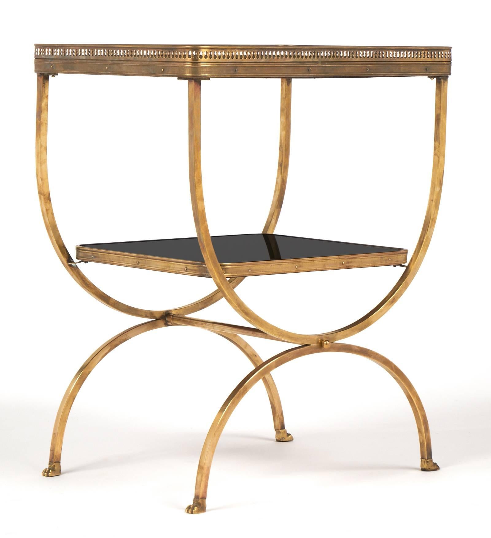 French vintage brass side table with finely cast gallery, Curule shape legs and claw feet. Two rounded corner black opaline glass shelves. A very elegant occasional table.