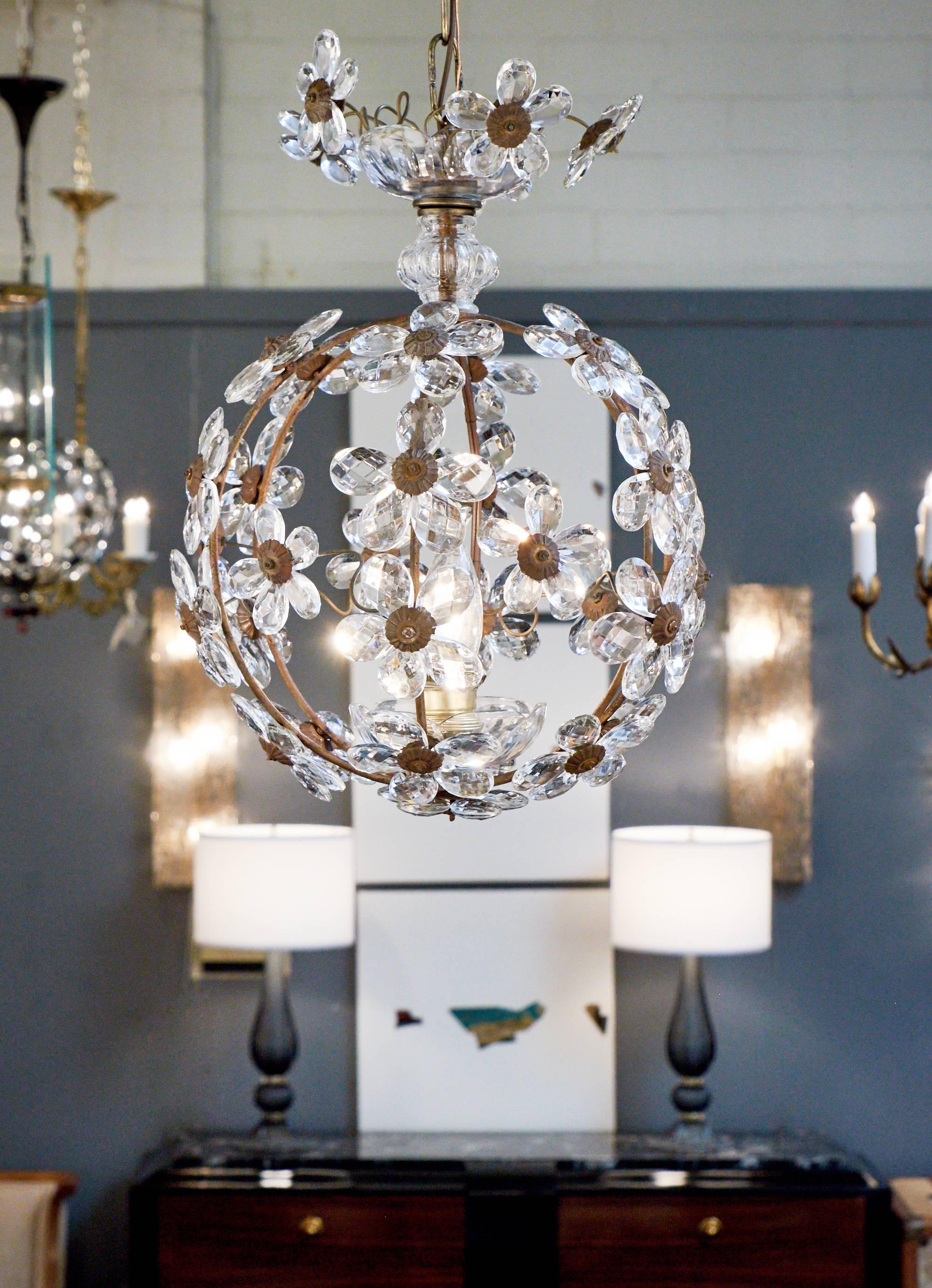 A lovely French antique pendant light chandelier of brass with flowers made of crystal petals. We love the simple round shape of this light fixture and the crystal canopy.

Holds one medium base bulb, rewired for the US. Height with brass chain