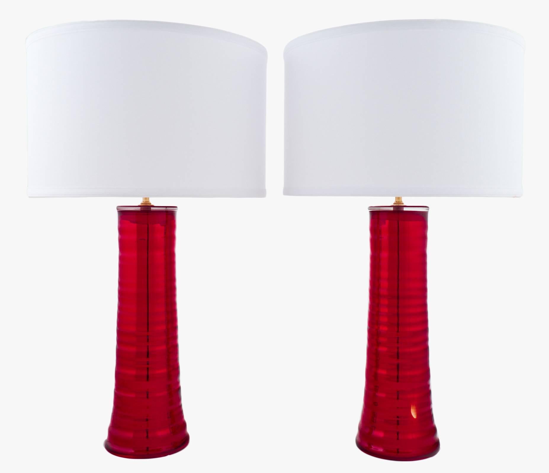 Italian Murano glass pair of lamps in a cherry red mirrored glass. A slightly rippled texture adds even more depth to the thick, high-quality Murano glass. The height of the glass is 16.75 inches. This fabulous pair of lights has been rewired for