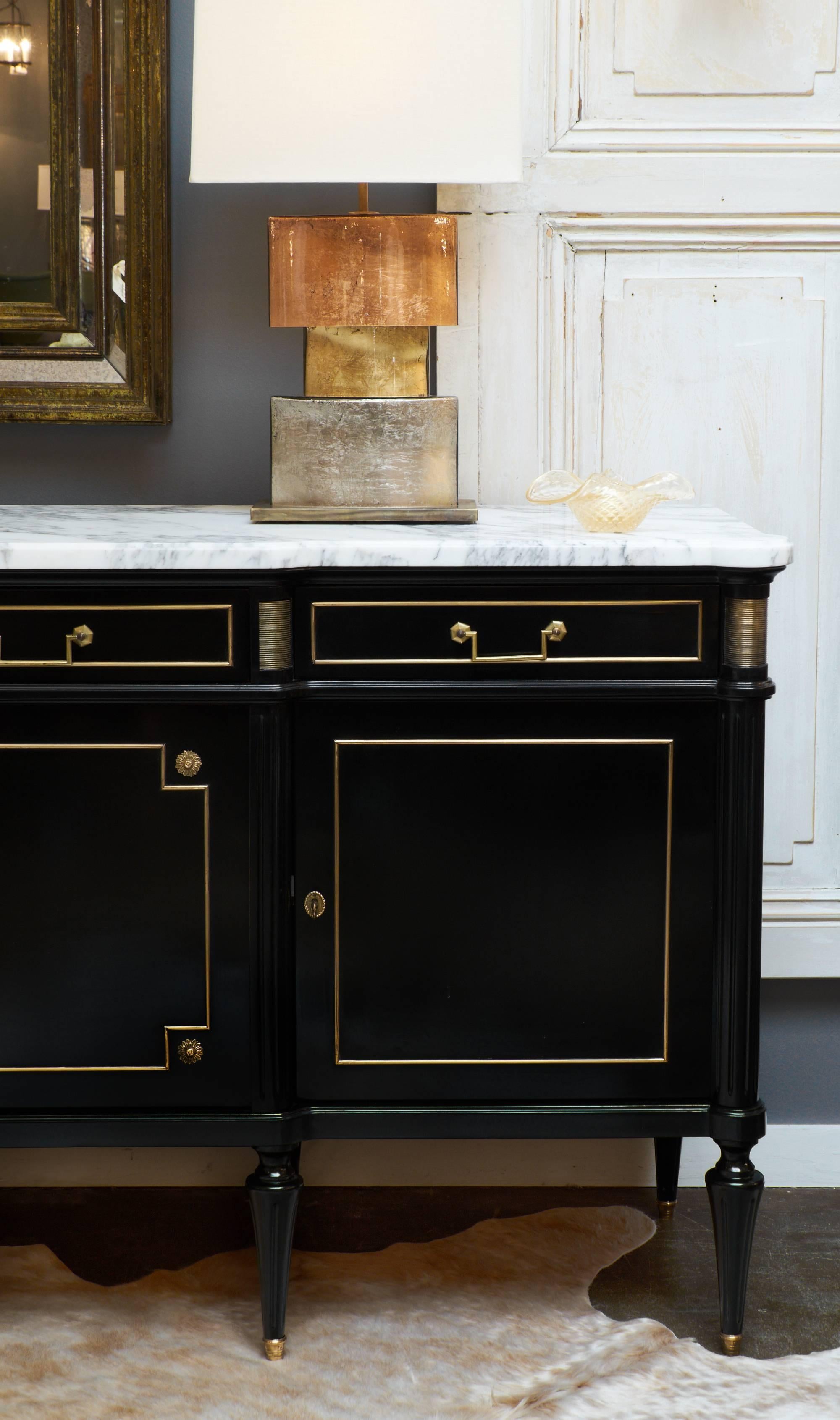 French antique Louis XVI style enfilade of ebonized mahogany with a flawless French polish finish. White Carrara marble top with beautiful gray veining. We couldn't resist the exquisite details, such as the brass trim, cast bronze details , and