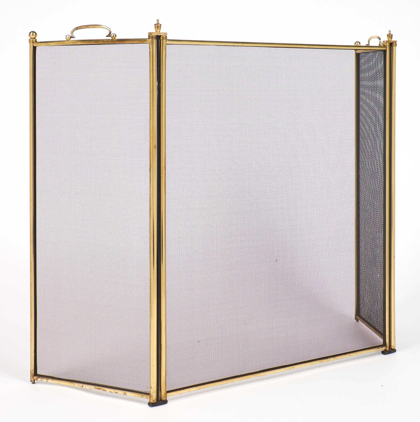 French brass fire screen with three mesh panels on hinges. A handle on each side panel provides easy maneuverability.
