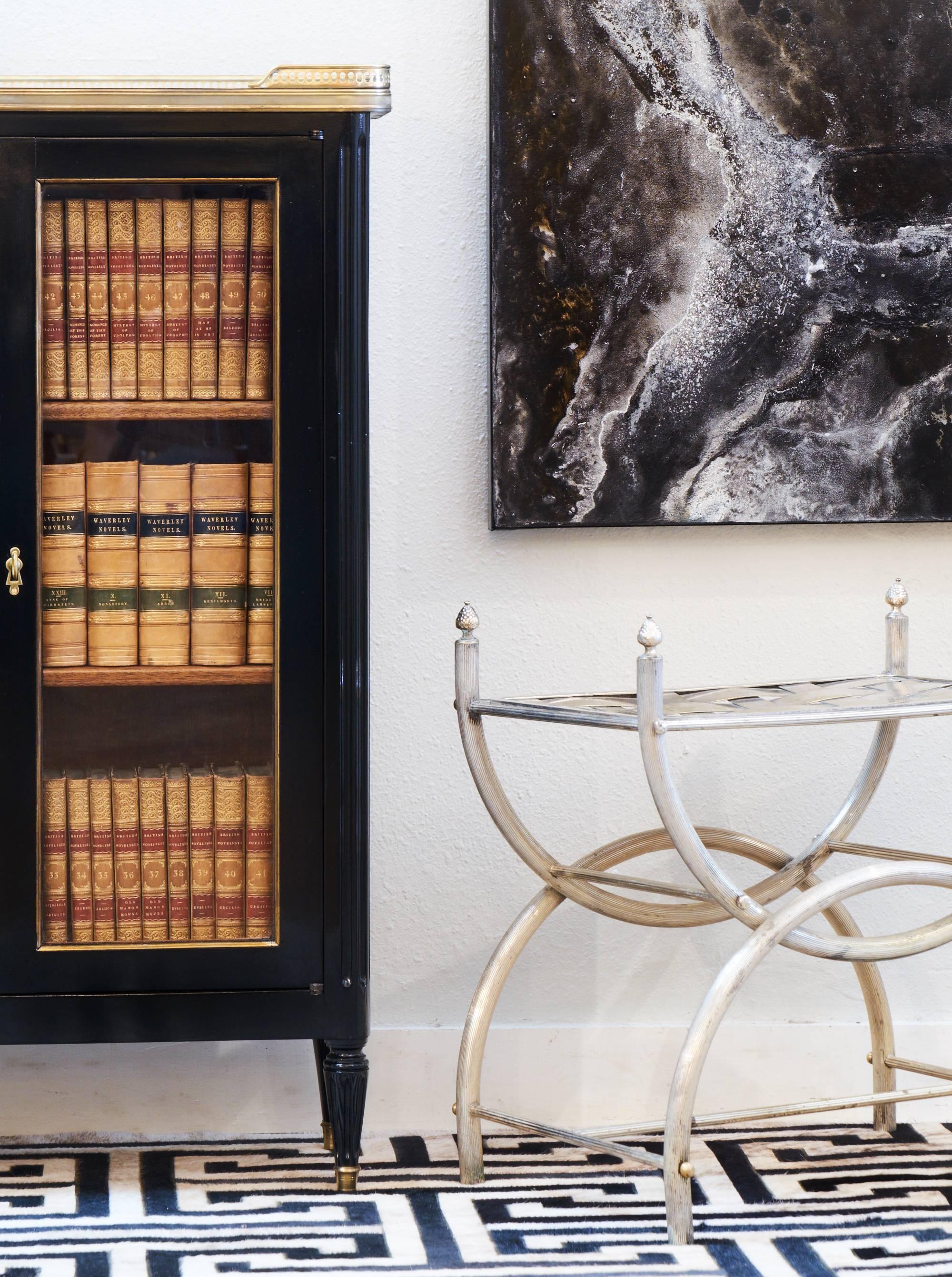 Antique French Louis XVI style vitrine of ebonized mahogany. Carrara marble top is surrounded by a finely cast brass gallery. Brass trim, hand-carved fluting, and two glass front doors. Two adjustable shelves in the mahogany interior. A charming