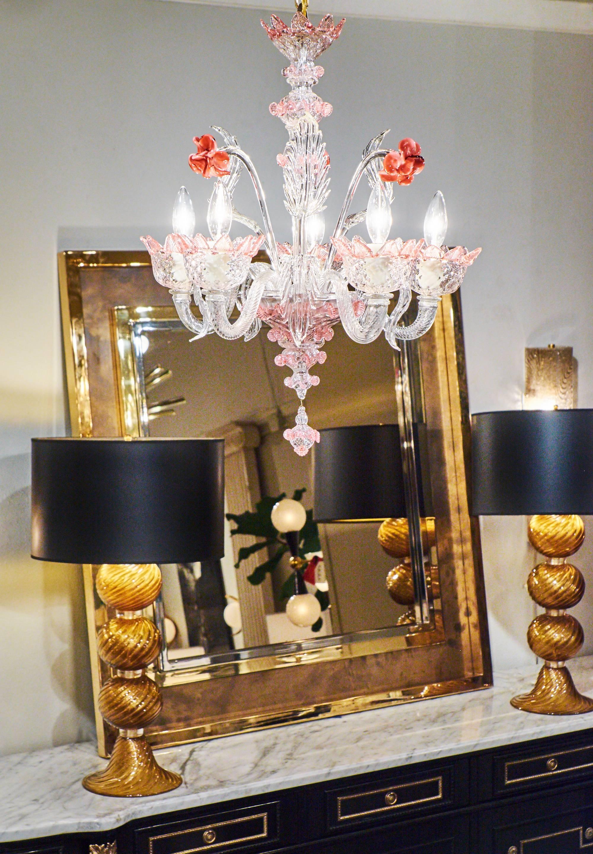 Charming and feminine, this gorgeously detailed Murano glass chandelier has five branches, three handcrafted roses and eight leaves extending from a central cup. Handblown crystal clear glass with pink accents. We love the layers of texture and