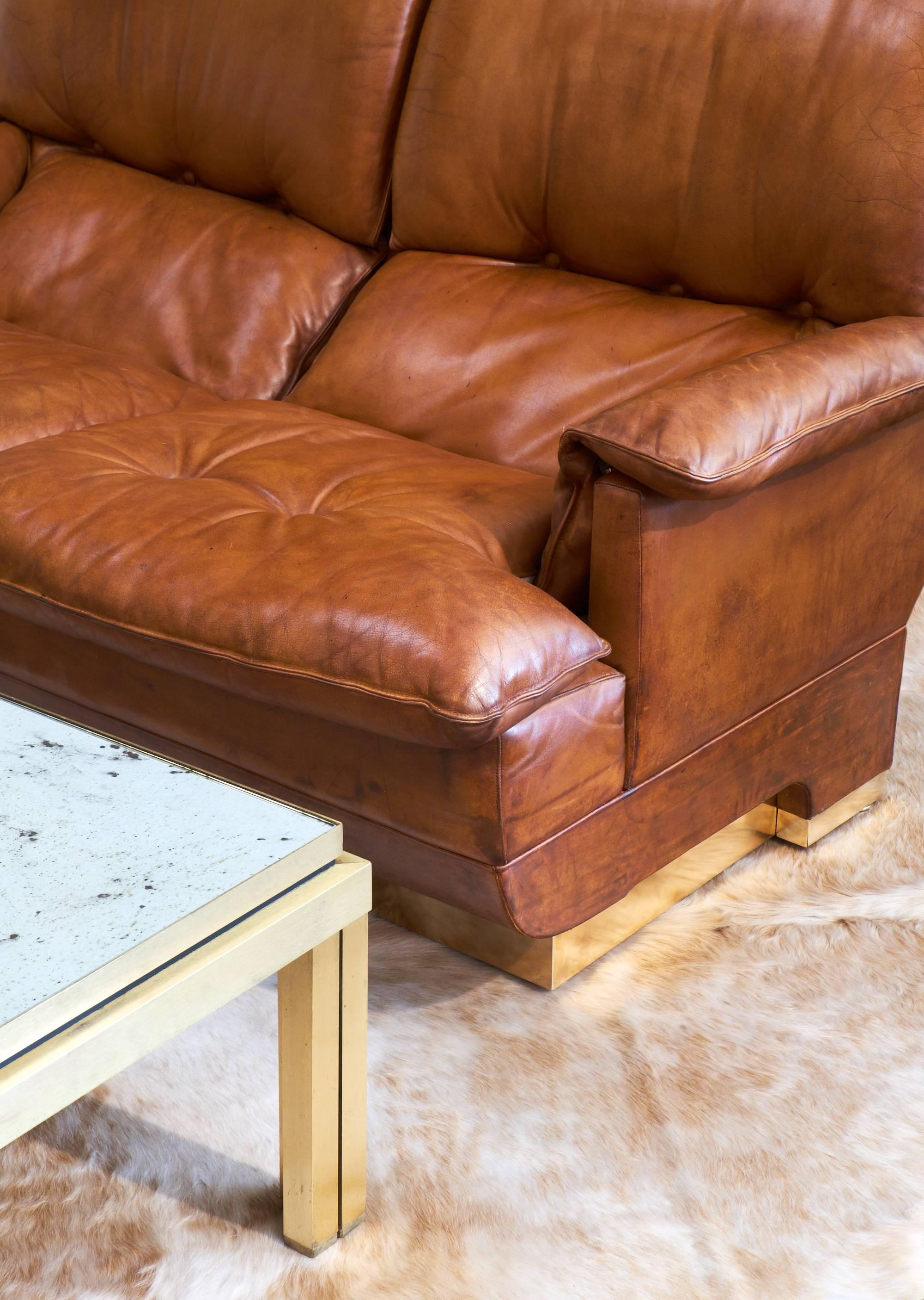 An incredibly comfortable and stylish French vintage leather sofa with brass wrapped base. We love the folded look of the cushions, the warm color, the great feel of the supple, vintage leather and the clean and bold brass base.

Ask us about the