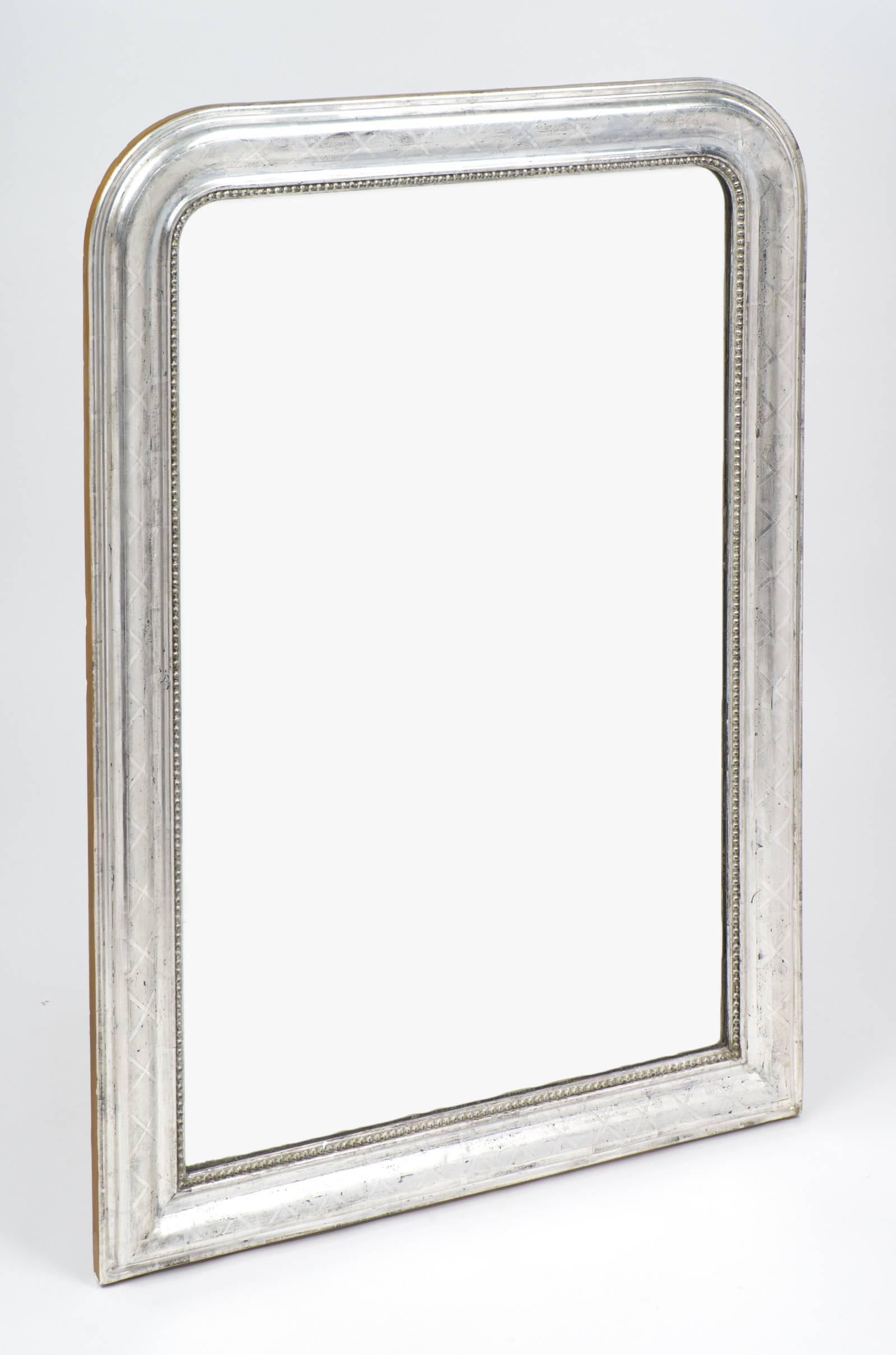 Antique French Louis Philippe period mirror. Silver leafed wood frame with beading all around and an etched geometric pattern.