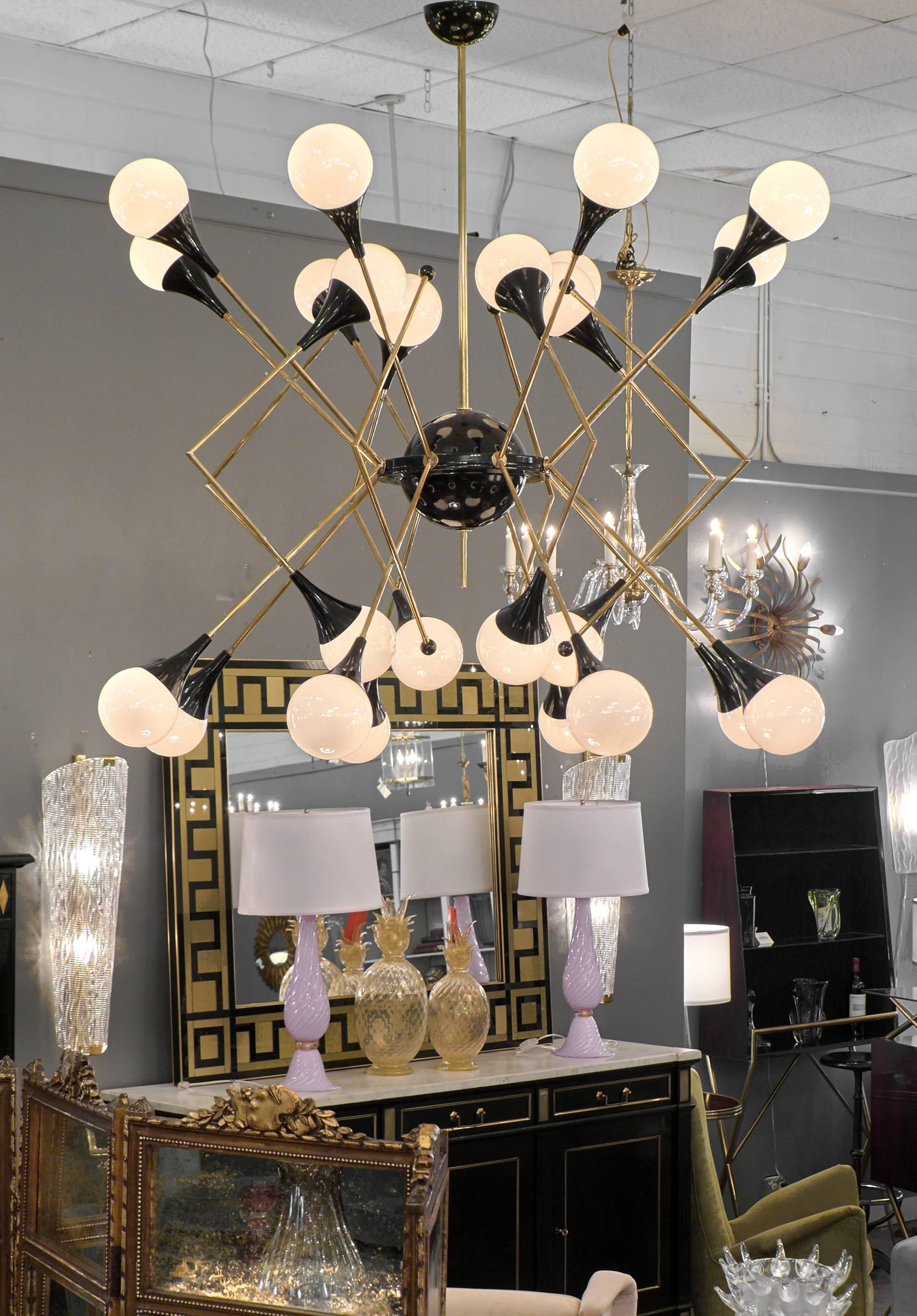 Italian mobile-style chandelier in the style of Stilnovo. A brass and black lacquered brass structure holds twenty-four Murano glass globes.
Rewired for the US.
