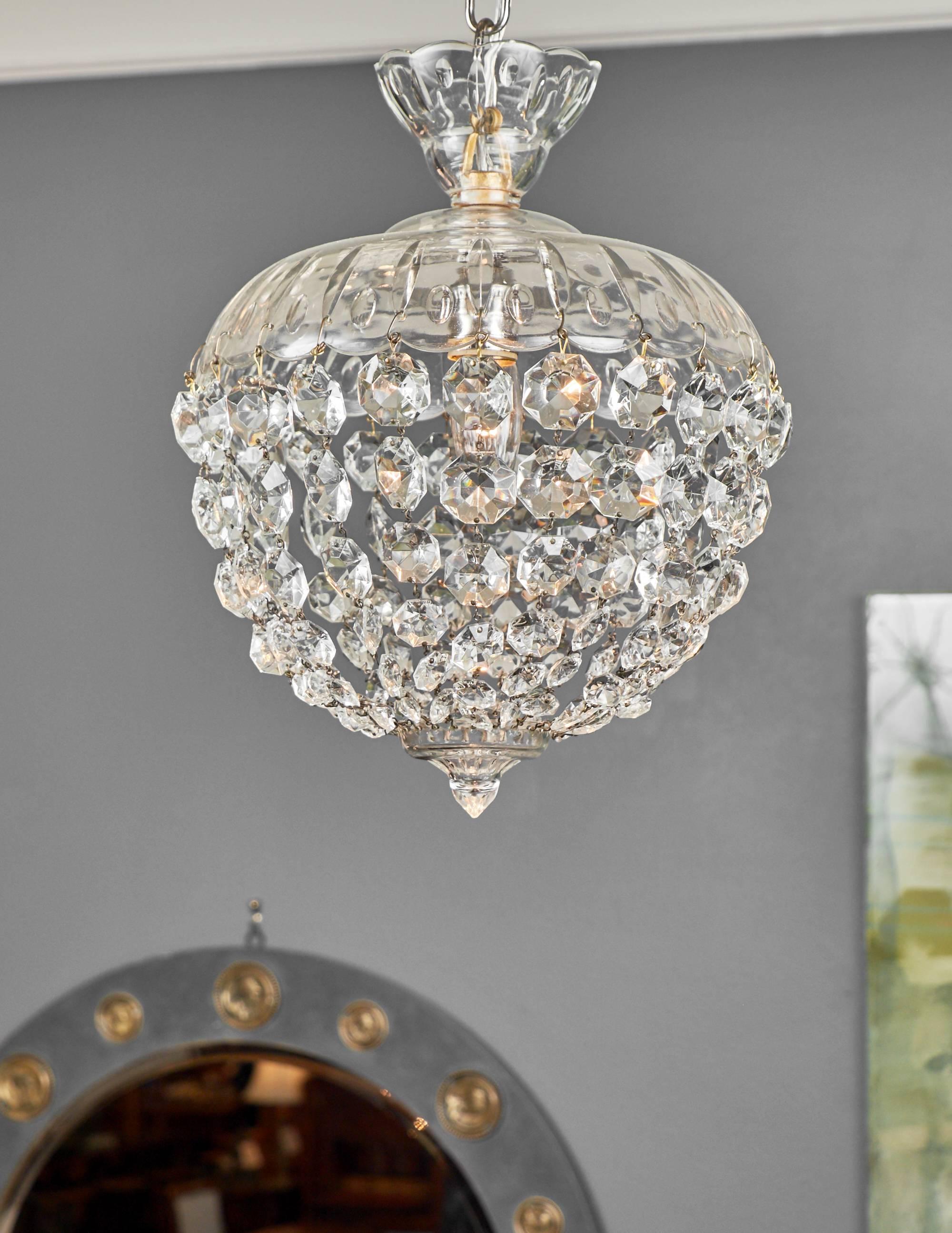 Crystal chandelier by Baccarat featuring a crystal dome from which hangs strings of crystals which come together in a crystal point. This beautiful piece is from 1920 France. This piece has been rewired for the US market, and it's height from the