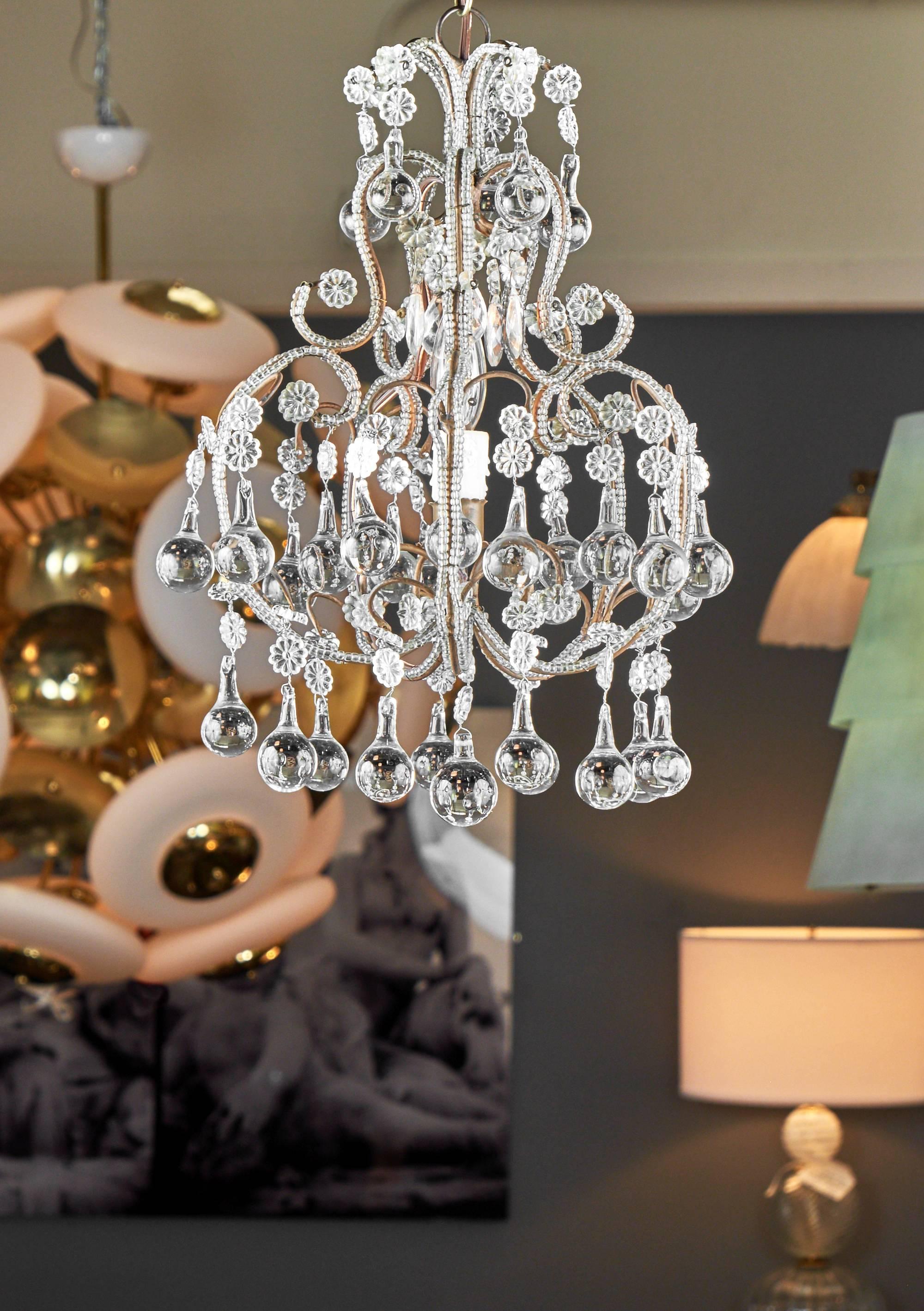 Glamorous and elegant crystal chandelier from Genova, on the Ligurian coast of Italy, gold leafed metal structure covered with crystal beads and a rich array of crystal water drop pendants, circa 1910. This charming piece has been rewired for the US