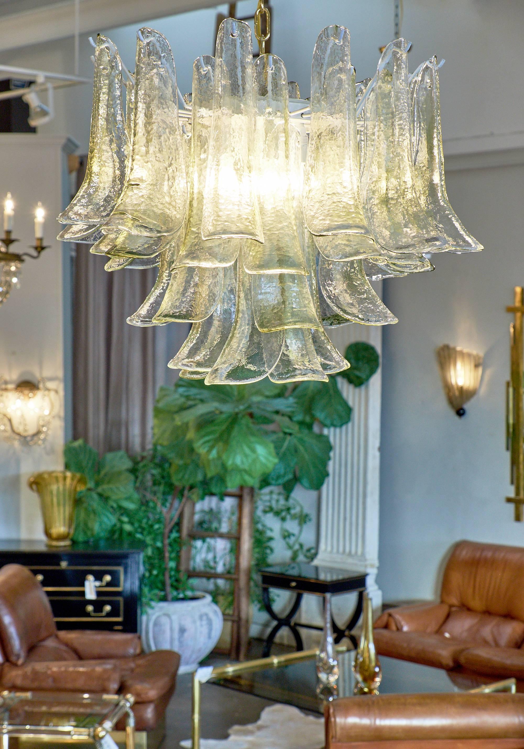 Clear Murano glass selle elements are layered to create a lovely feathered effect for this stunning, unique chandelier. The light comes through the glass for a beautiful, modern look. This wonderful chandelier is the perfect size for a dining room