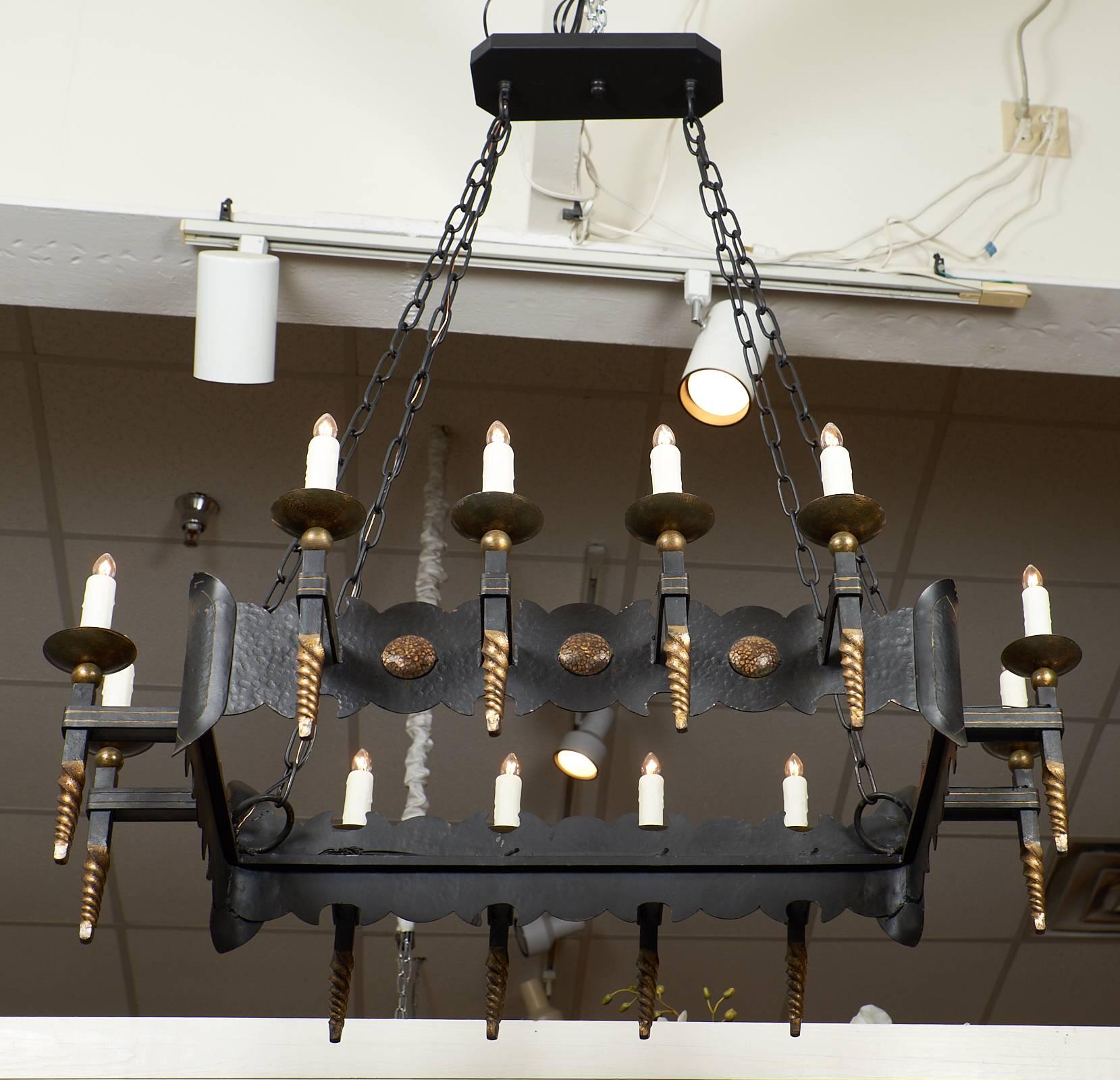 Hand-hammered and forged, this impressive antique Renaissance style chandelier has ten lights and is from the Burgundy region of France. This piece has a wonderful combination of gold leafed details and dark iron. The texture is great and the piece