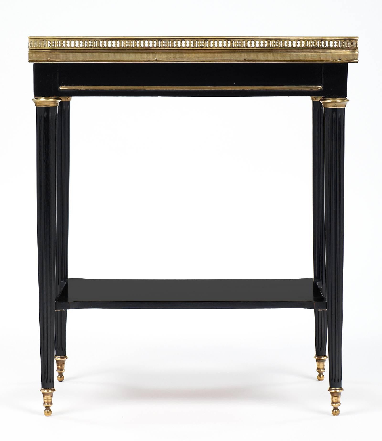 Charming Louis XVI style antique French side table. This piece has a beautiful Carrara marble top, bronze feet and capitals, and finely crafted gilt brass trims and gallery. We can't resist the precise craftsmanship and the refined feel of the piece!