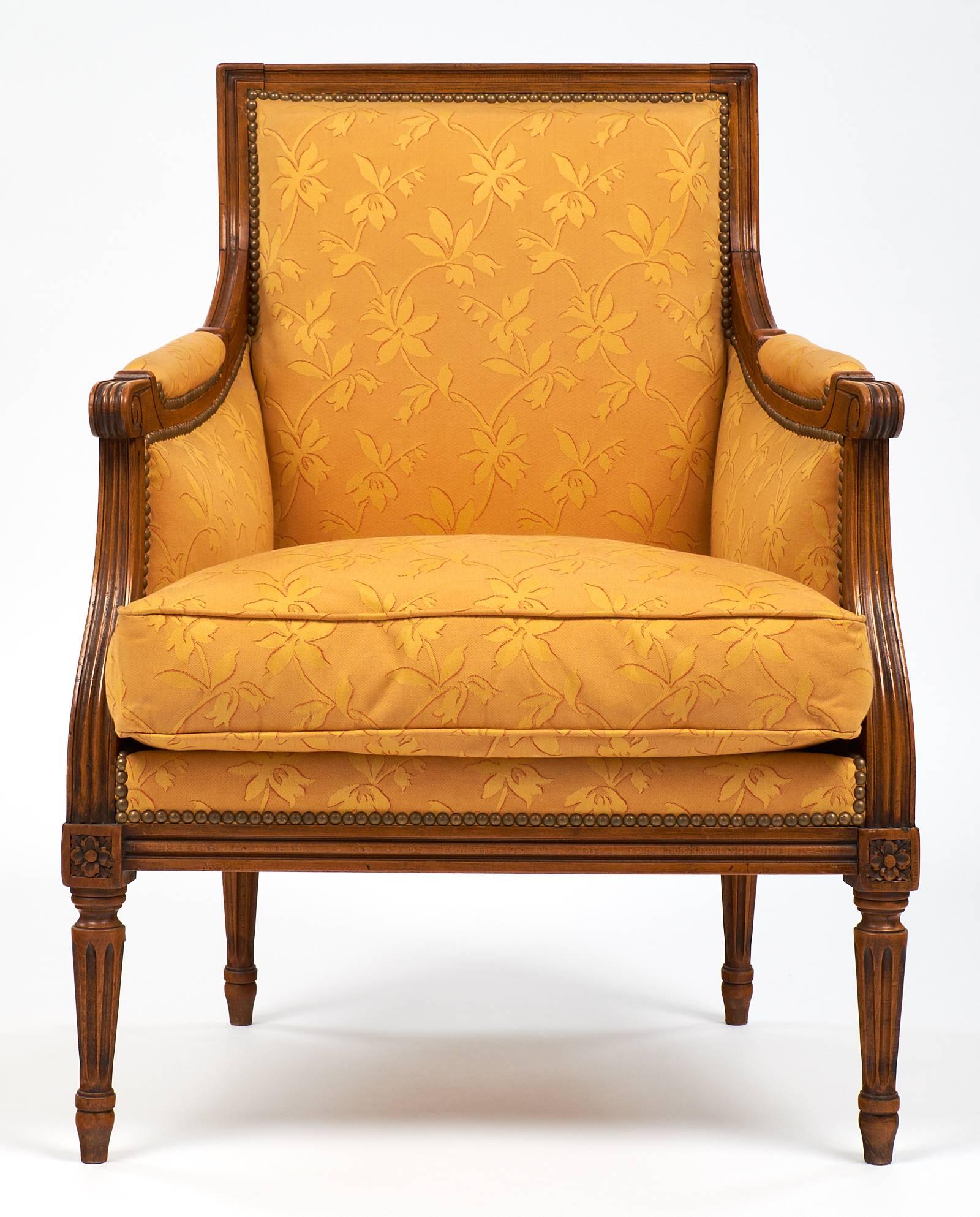 Vintage French Louis XVI style bergères with solid cheerywood frames and complimentary fabric upholstery in a floral pattern. The legs have hand-carved fluting and details! Each chair features a square back and down filled pillows. We love the