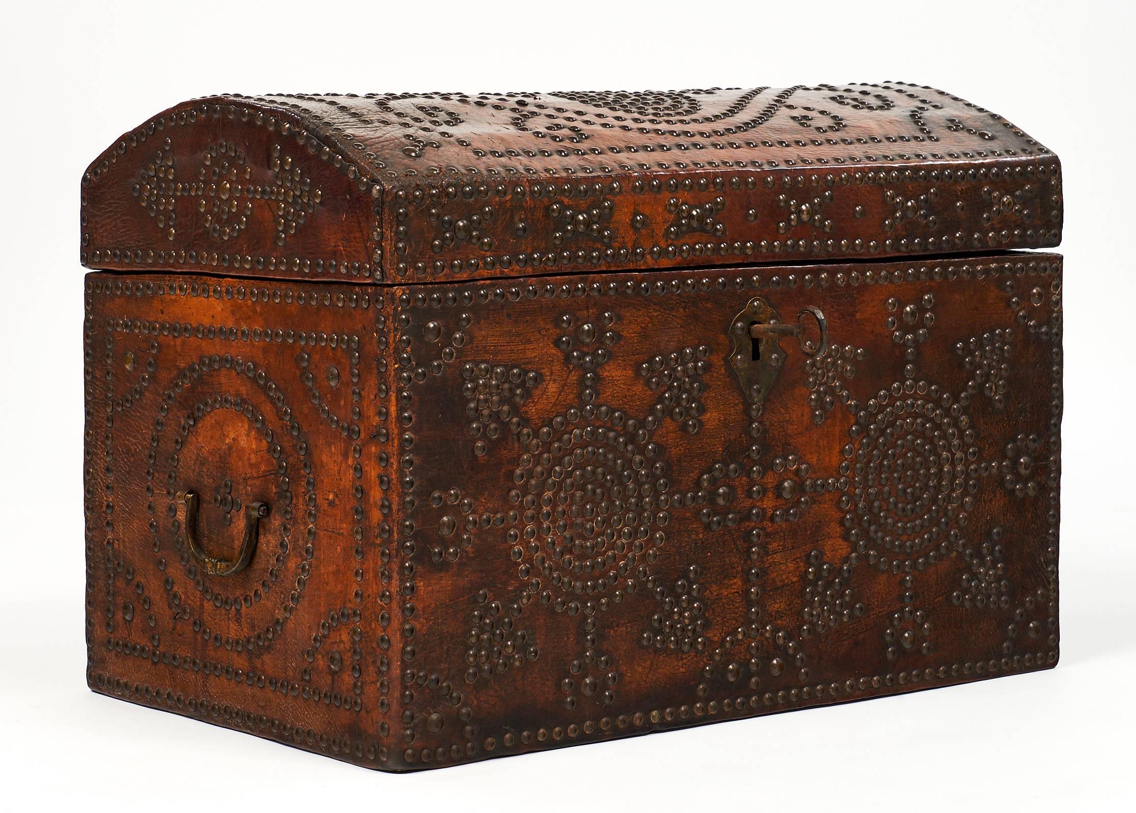 Large and wonderful French Napoleon III period leather box covered with leather and made of solid oak. This chest has intricate Renaissance patterns tooled in brass head tacks. The key and lock are original. Authenticity is added to the piece with