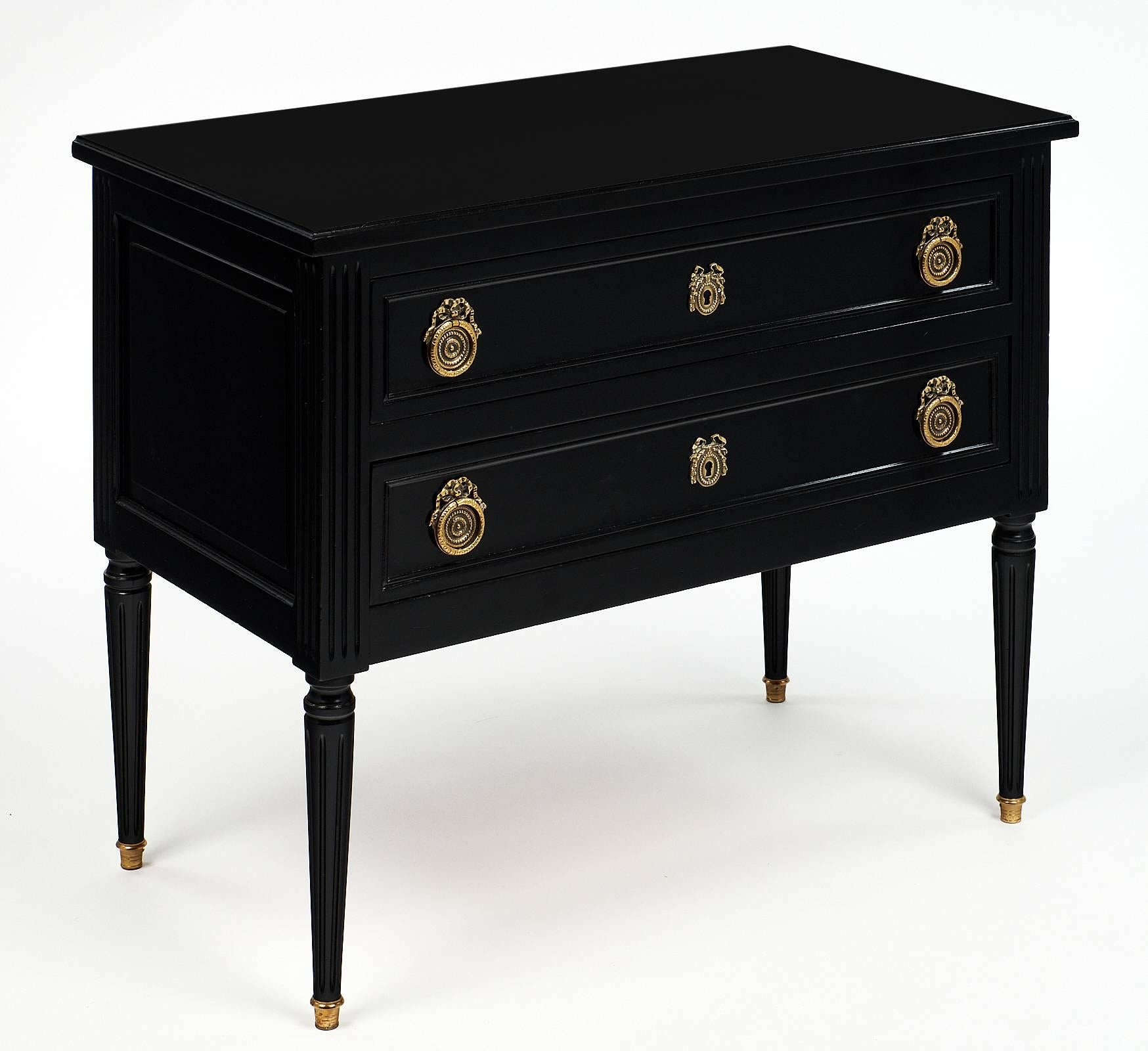Made of solid ebonized walnut, this charming commode sauteuse is finished with a wonderful French polish. This piece has two dovetailed drawers and finely cast bronze hardware.