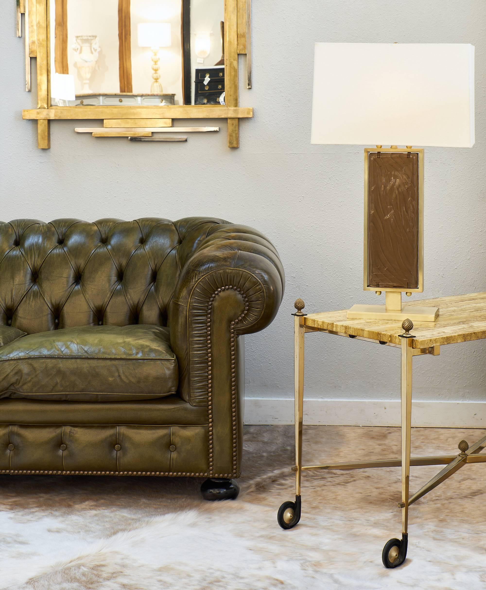 Wonderful side table on casters and made of gilded brass with finely cast finials. The top is a richly veined onyx. We love the elegant X-shaped stretcher and the tapered legs.

 