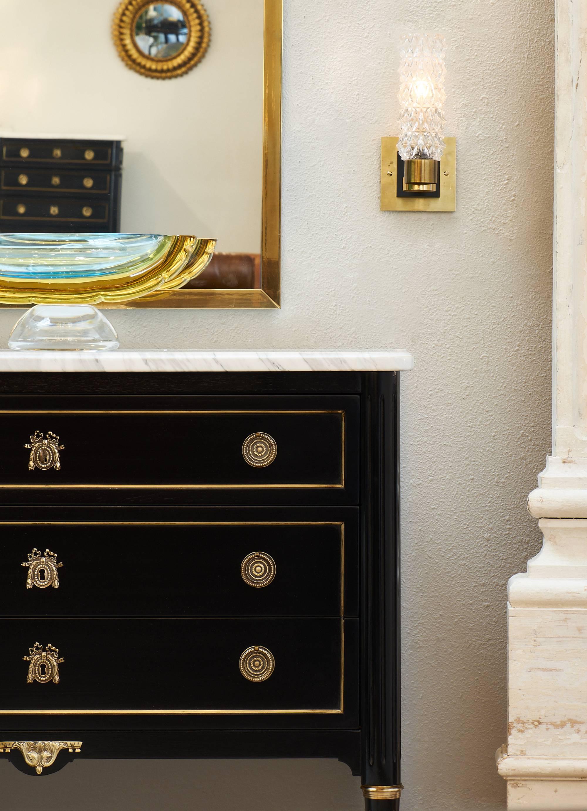 Lovely and fine chest of drawers featuring three dovetailed drawers and a richly veined Carrara marble top. The wonderful piece has gilt trim throughout and finely cast bronze hardware, ormolu details, and fluted legs. This is the perfect occasional