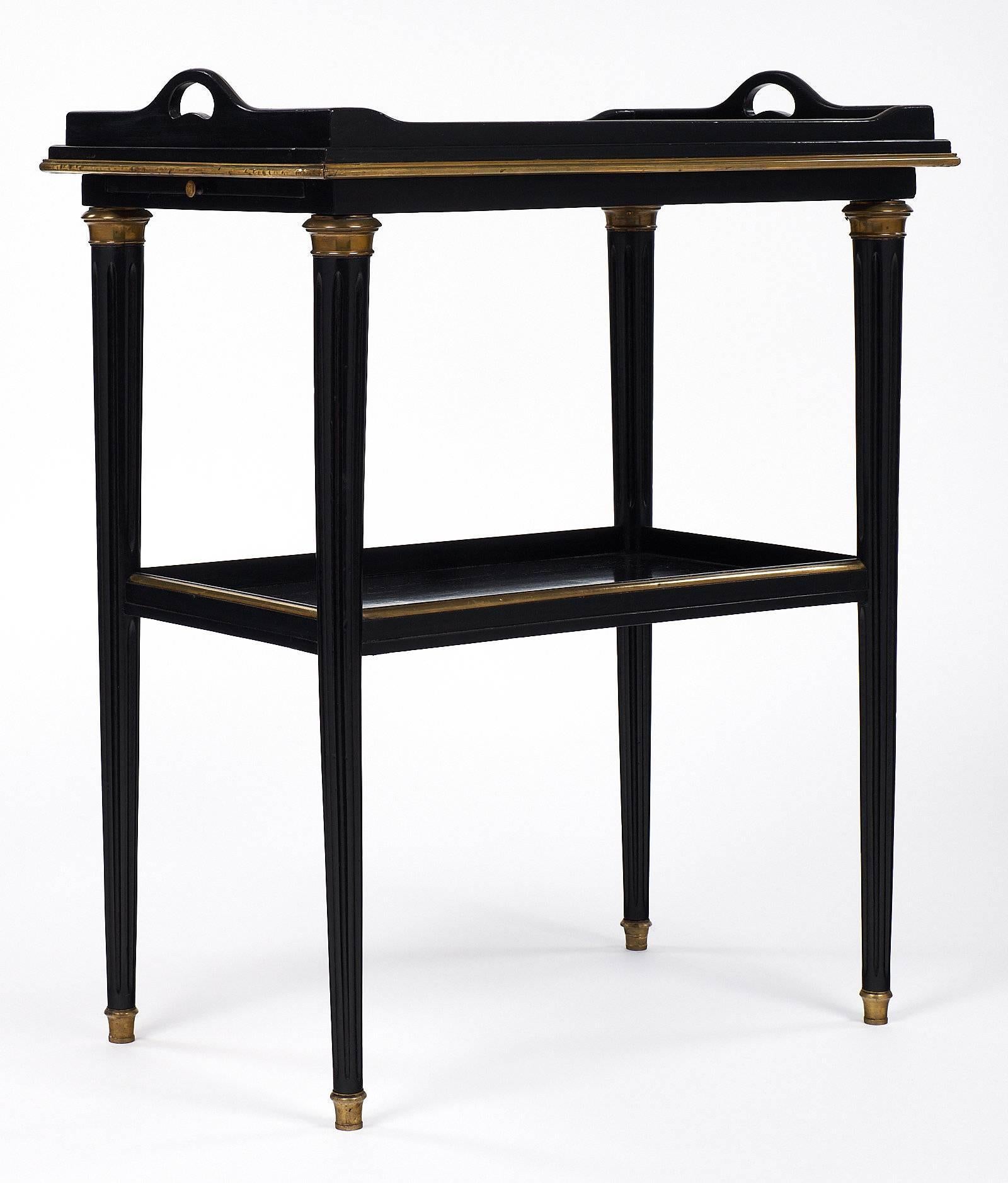 Lovely Napoleon III period antique French tray table in the Louis XVI style. This wonderful piece features a detachable try and a pull-out extension leaf. It has been ebonized and finished with a French polish. The table has bronze ormolu decor and