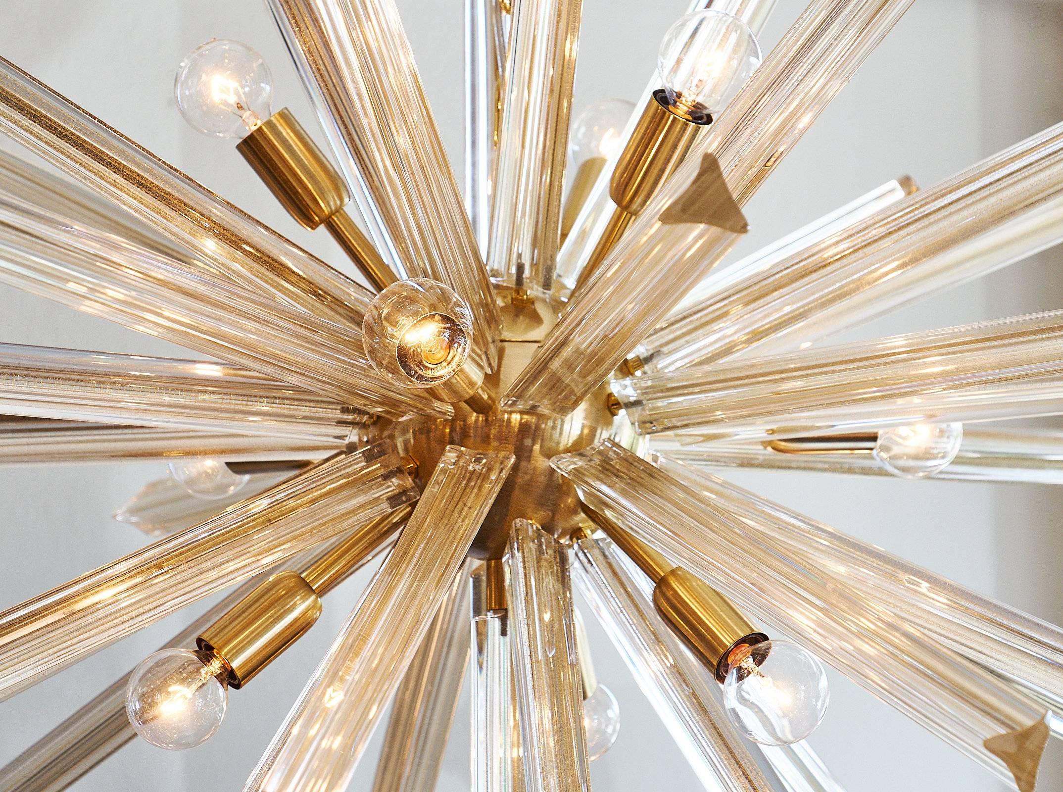 Italian Murano modernist chandelier of over 40 “Triedi” avventurina stems fused with 23-karat gold flecks. The stems shoot out from a brushed gold steel sphere to form this dynamic and eye-catching fixture. This piece has been rewired for the US