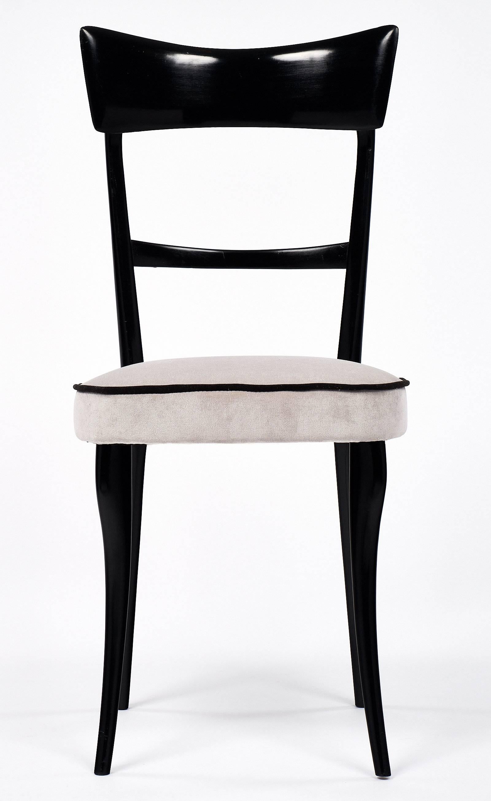 Six elegant Italian dining chairs in the style of Paolo Buffa. These ebonized chairs have been finished with a lustrous French polish and reupholstered with a grey velvet blend. We love the sophisticated legs and black piping. This set has both
