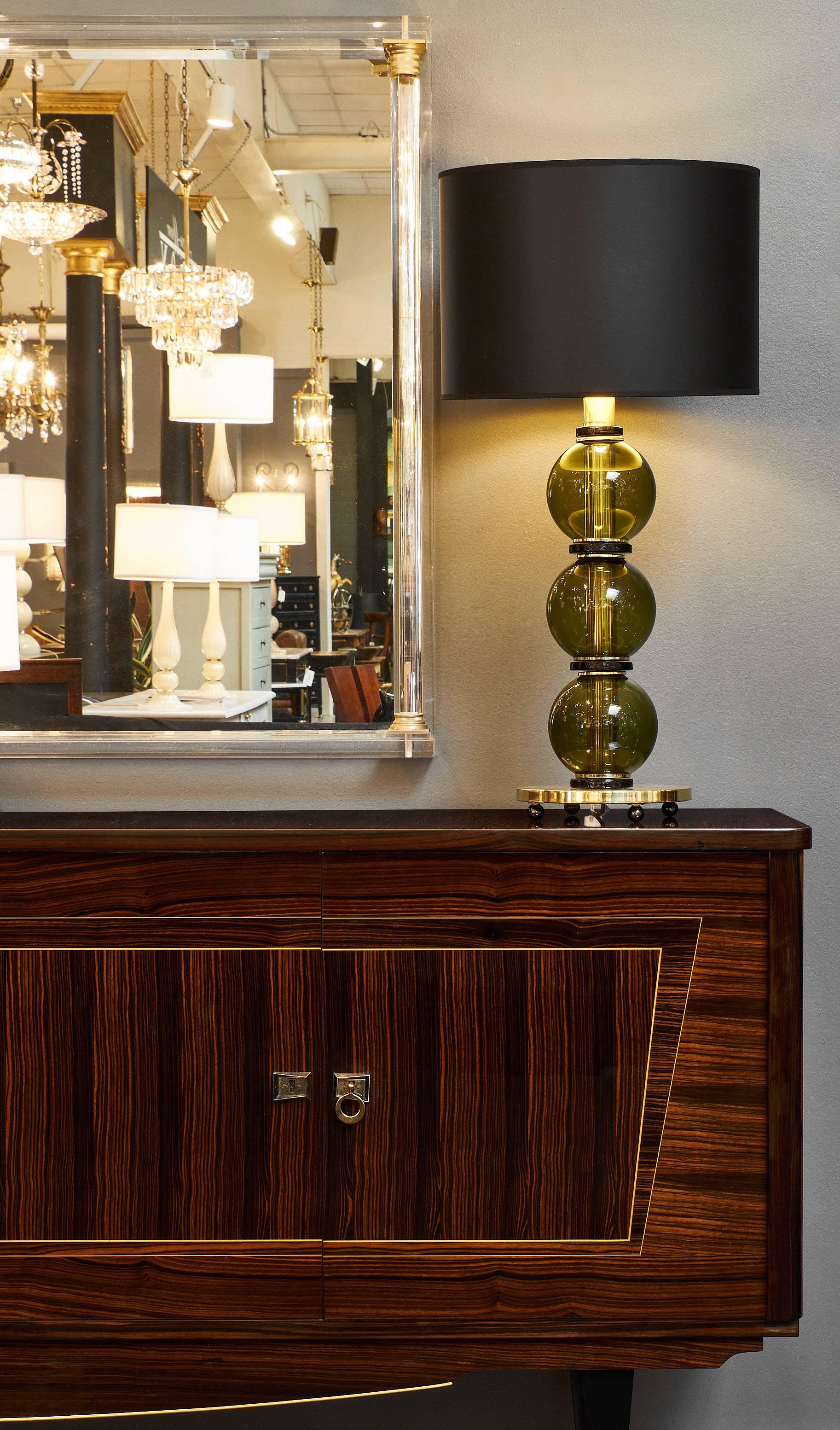 Murano green handblown spheres, brass components, and black glass rings make up this stunning pair of lamps. We also love the brass base with its round spherical feet. This stunning pair has been rewired for the US market. The height to the top of