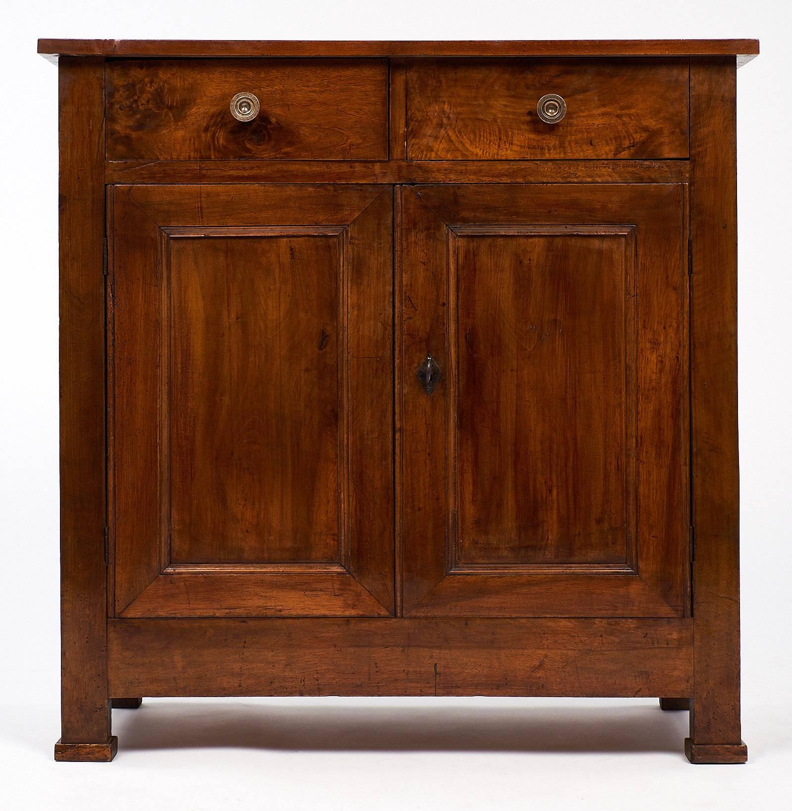 This lovely antique French Restauration period buffet is made of beautiful walnut wood. The piece has two doors below two drawers. The great proportions of the piece also balance well with the fantastic original patina. The lock and key are in